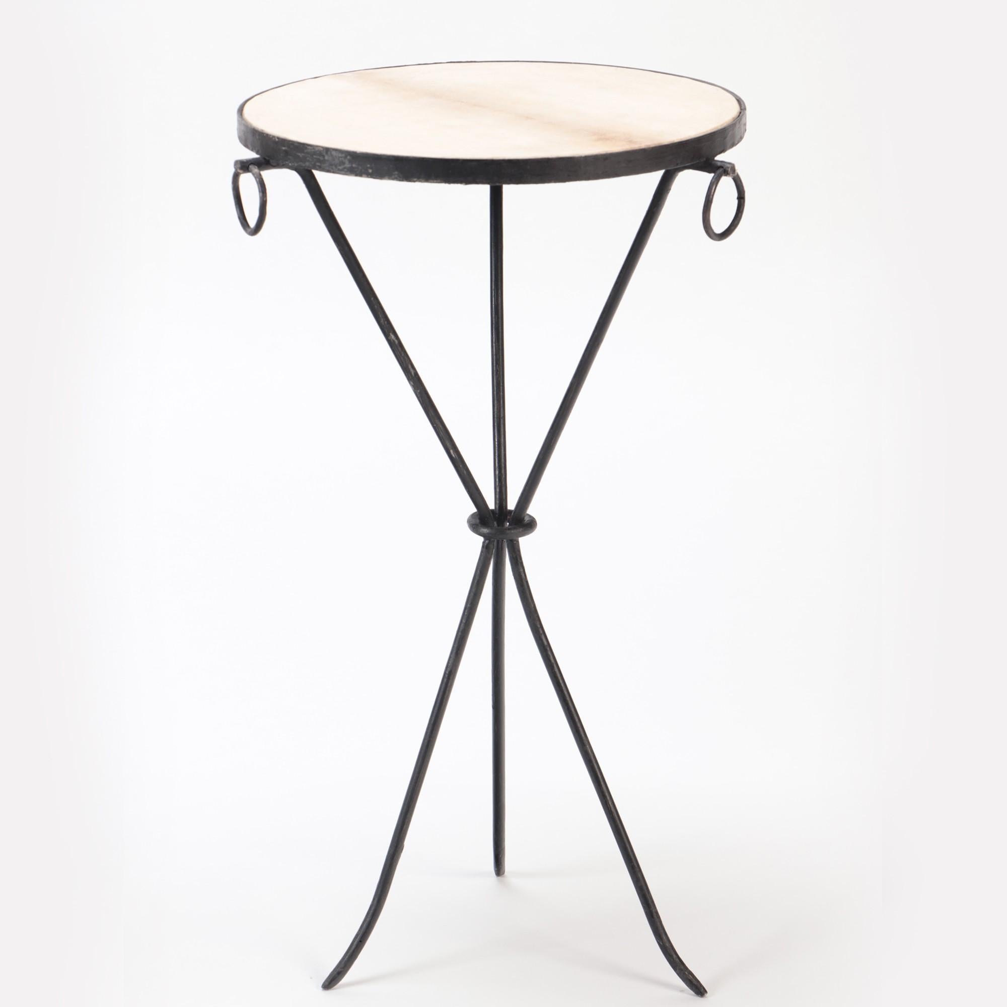 A pair of drinks tables composed of hand wrought iron with three brass ring decorations in the manner of Jean-Michel Frank with parchment tops. The pieces have a sleek tripod form.