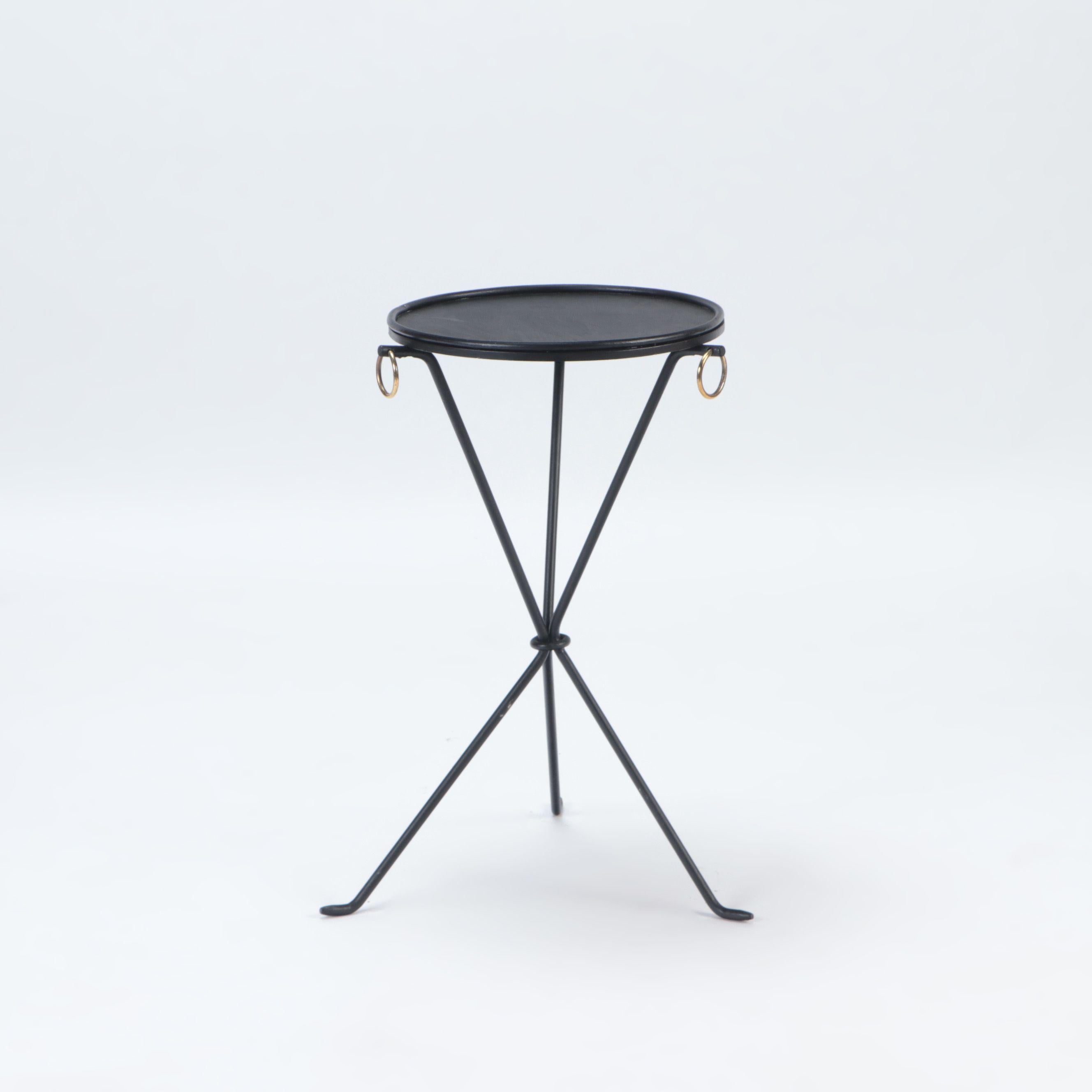 A pair of wrought iron drink tables with brass rings in the manner of Jean-Michel Frank. Contemporary. The tables rest on a sleek tripod form base.