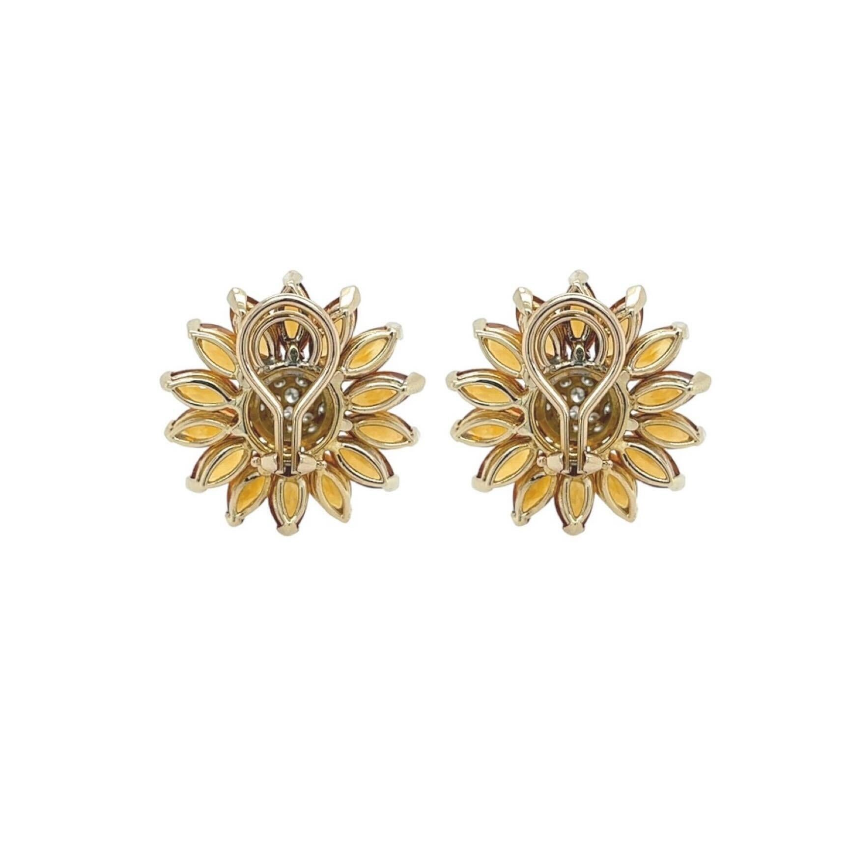 A pair of 14 karat yellow and white gold, citrine and diamond earclips.  Each earclip designed as a flower with petals of fourteen yellow gold set marquise cut citrines, the bombe center of the flower displaying approximately nineteen white gold set