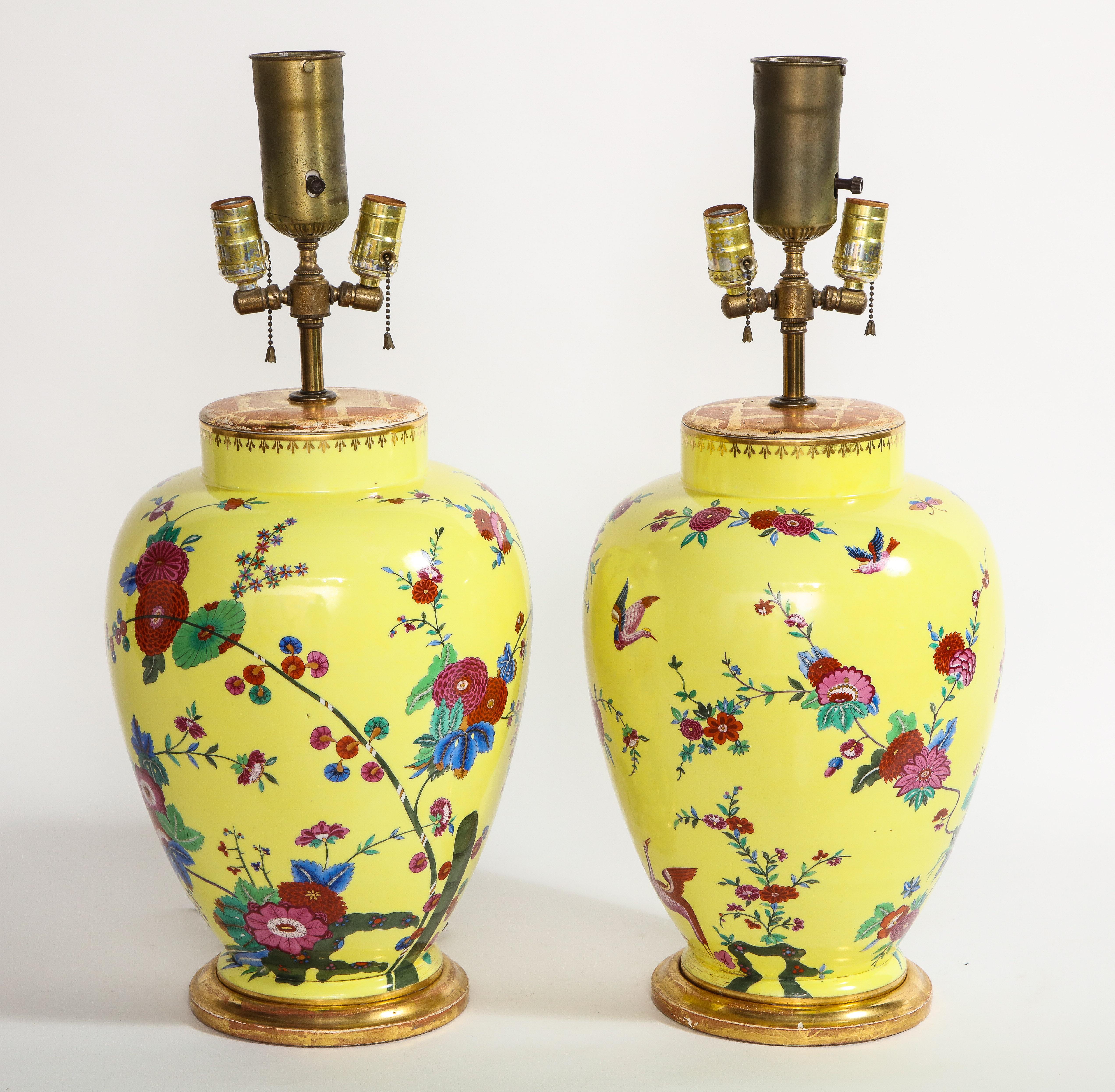Une paire de beaux vases en porcelaine allemande à fond jaune montés comme lampes, peints à la main avec des décorations de fleurs, d'oiseaux et d'insectes. Chacune de ces lampes est joliment peinte à la main avec un magnifique fond jaune et