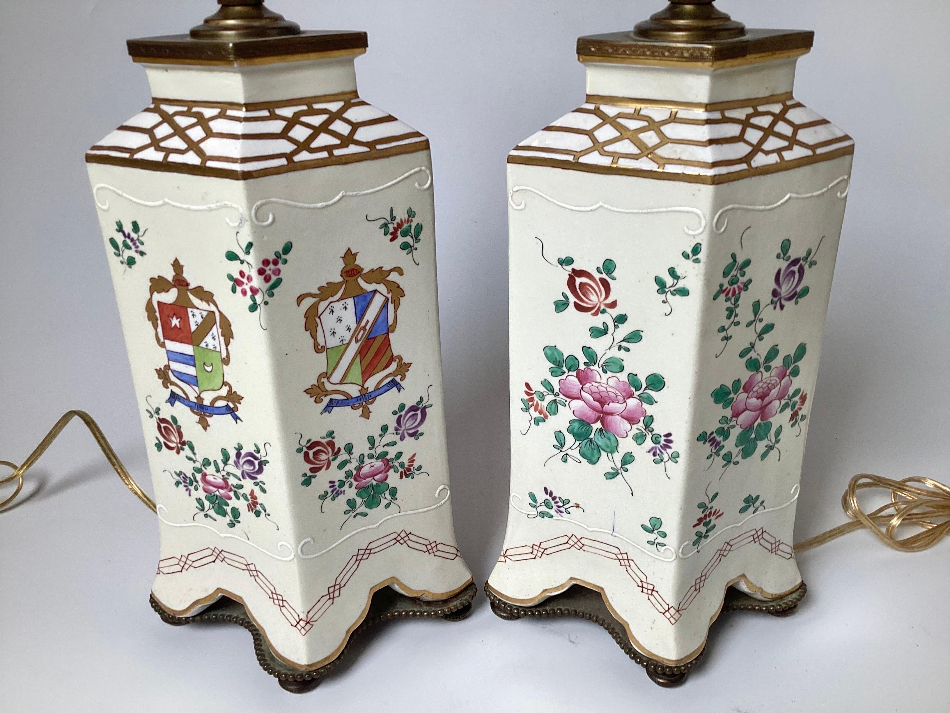 Une élégante paire de lampes de table en porcelaine française de style Samson, décorées d'un armorial. Elles sont marquées 