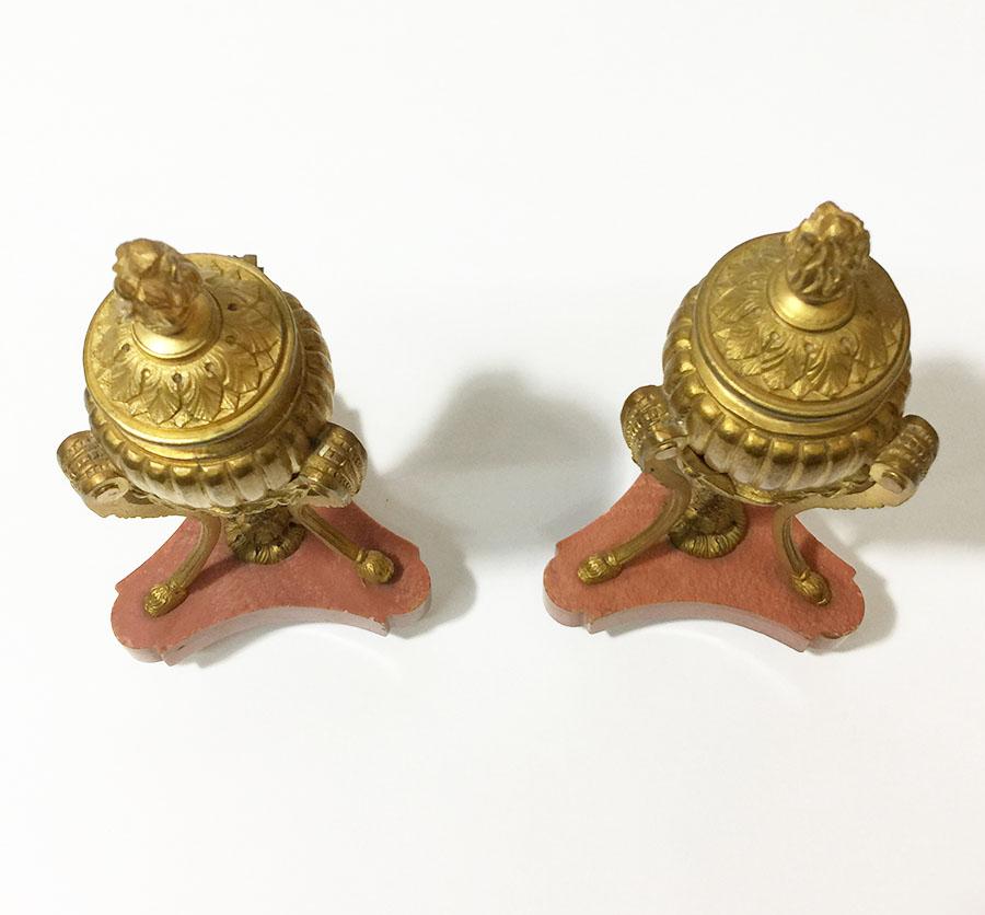 A pair small French 19th century gilt bronze cassolettes

19 cm high cassolettes on marble foot with a base on tripod legs with guirlandes and each has a reversible cover with flaming finals, which can be used as candleholders.
A leg under the