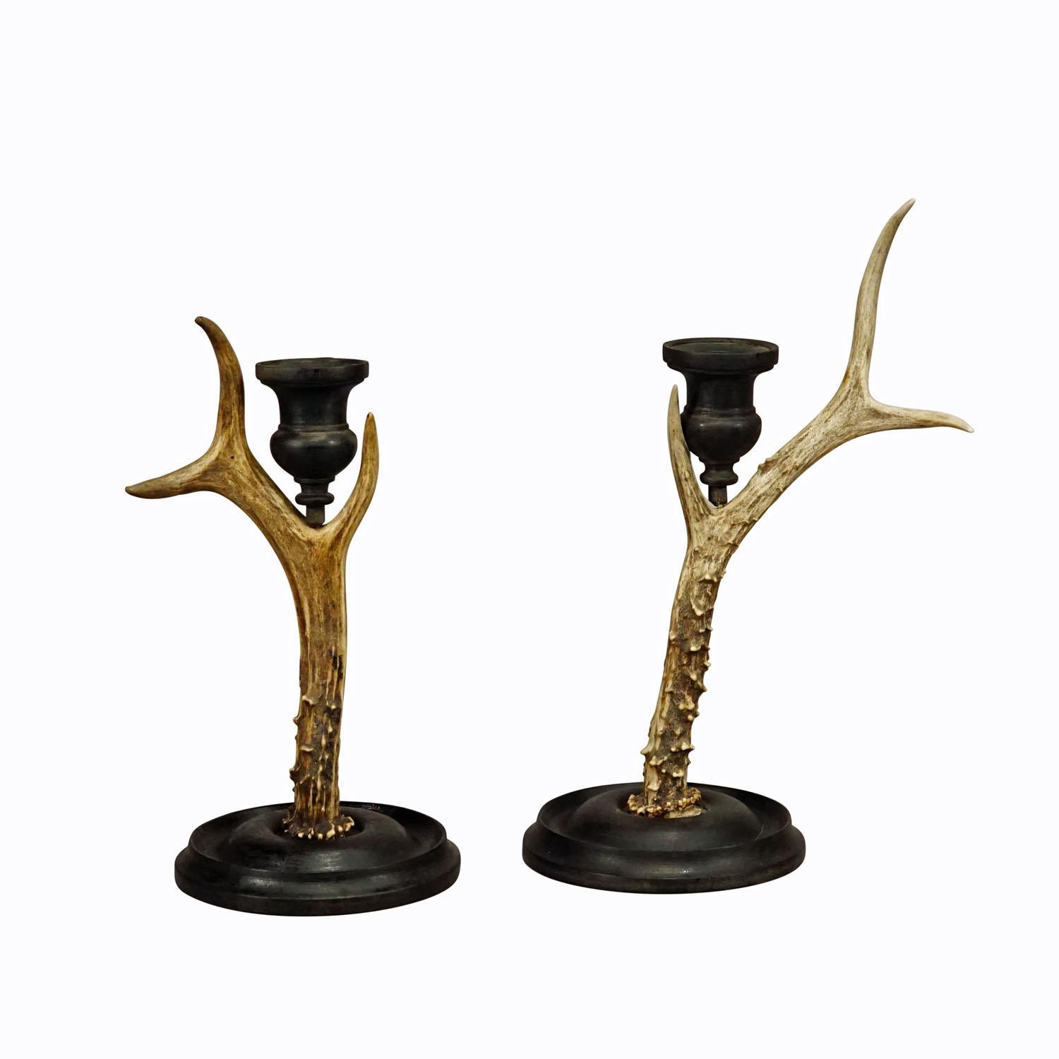 A Pair Vintage Black Forest Candle Holders with Wooden Base and Spout, Germany ca. 1930s

A pair of Black Forest candle holders with wooden turned base and spouts. Each made with an original deer antler. Manufactured in South Germany mid 20th