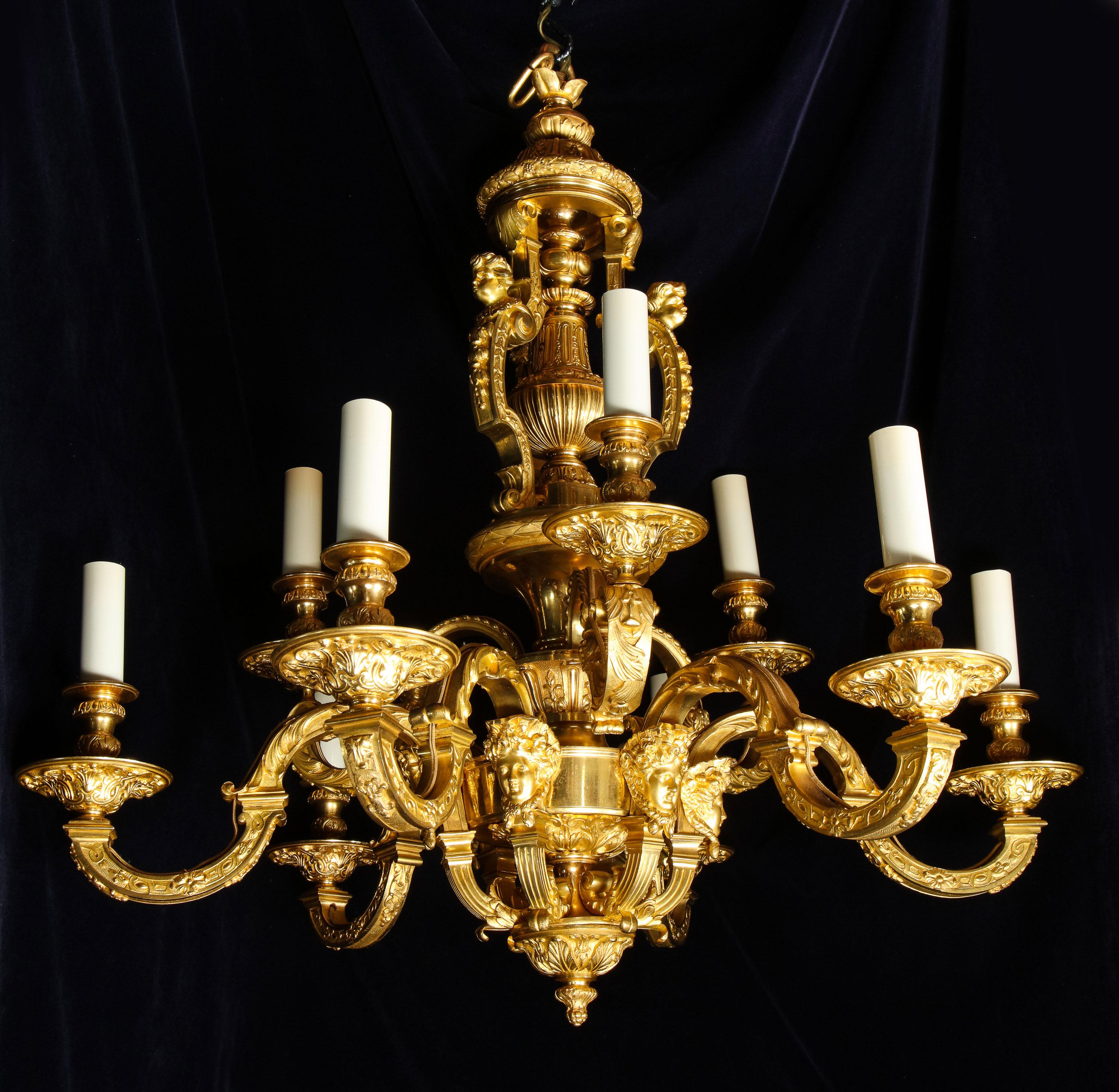 A palatial and large antique French Louis XVI gilt bronze figural double tier multi light chandelier of exquisite craftsmanship embellished with the most intricate detail and further adorned with figural masks.