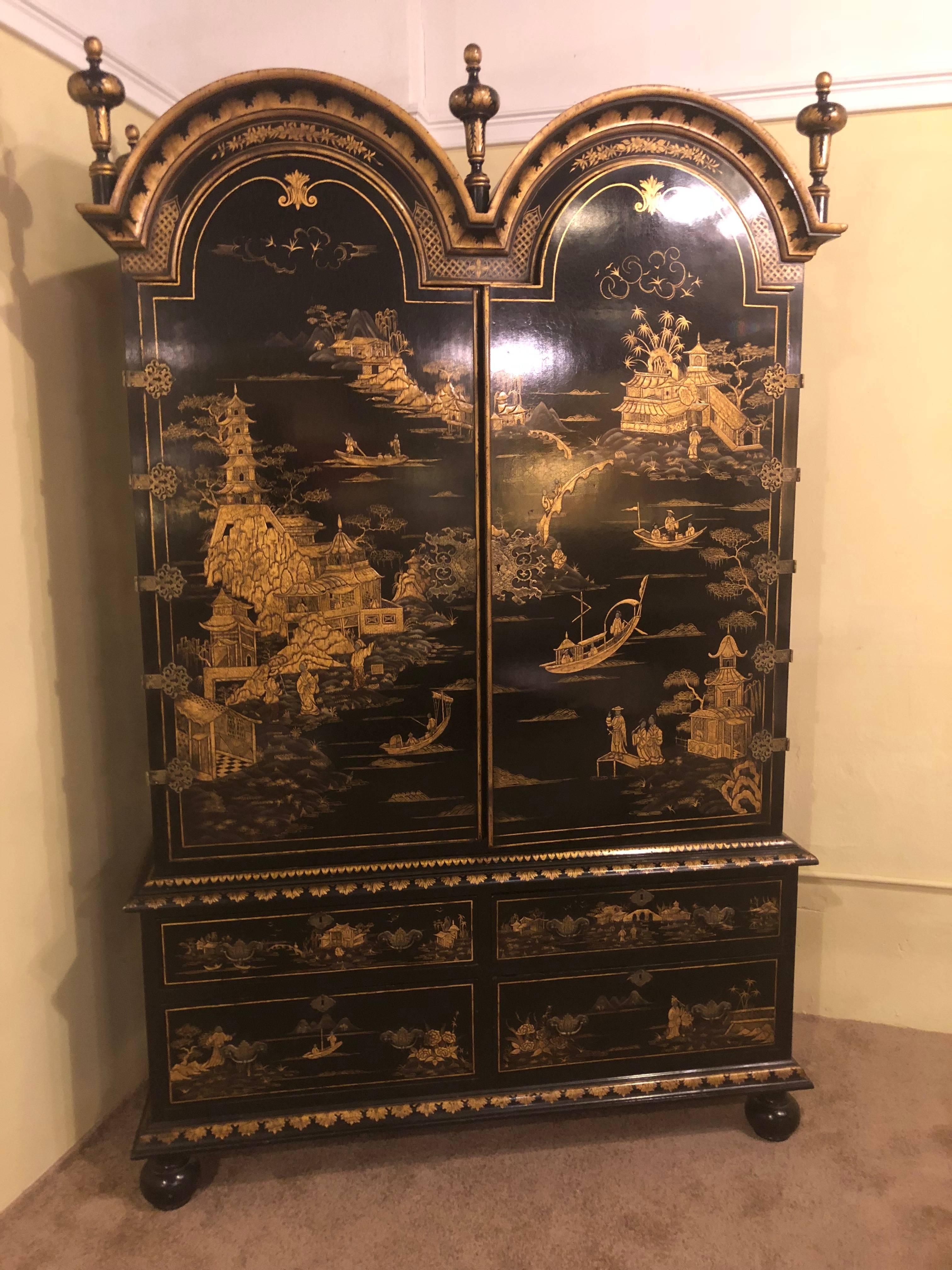 A Palatial chinoiserie decorated ebonized two-door over four drawer armoire. This spectacular armoire can easily be converted into a television cabinet or entertainment centre. The finely ebonized base with raised paint decorated scenes of figures,