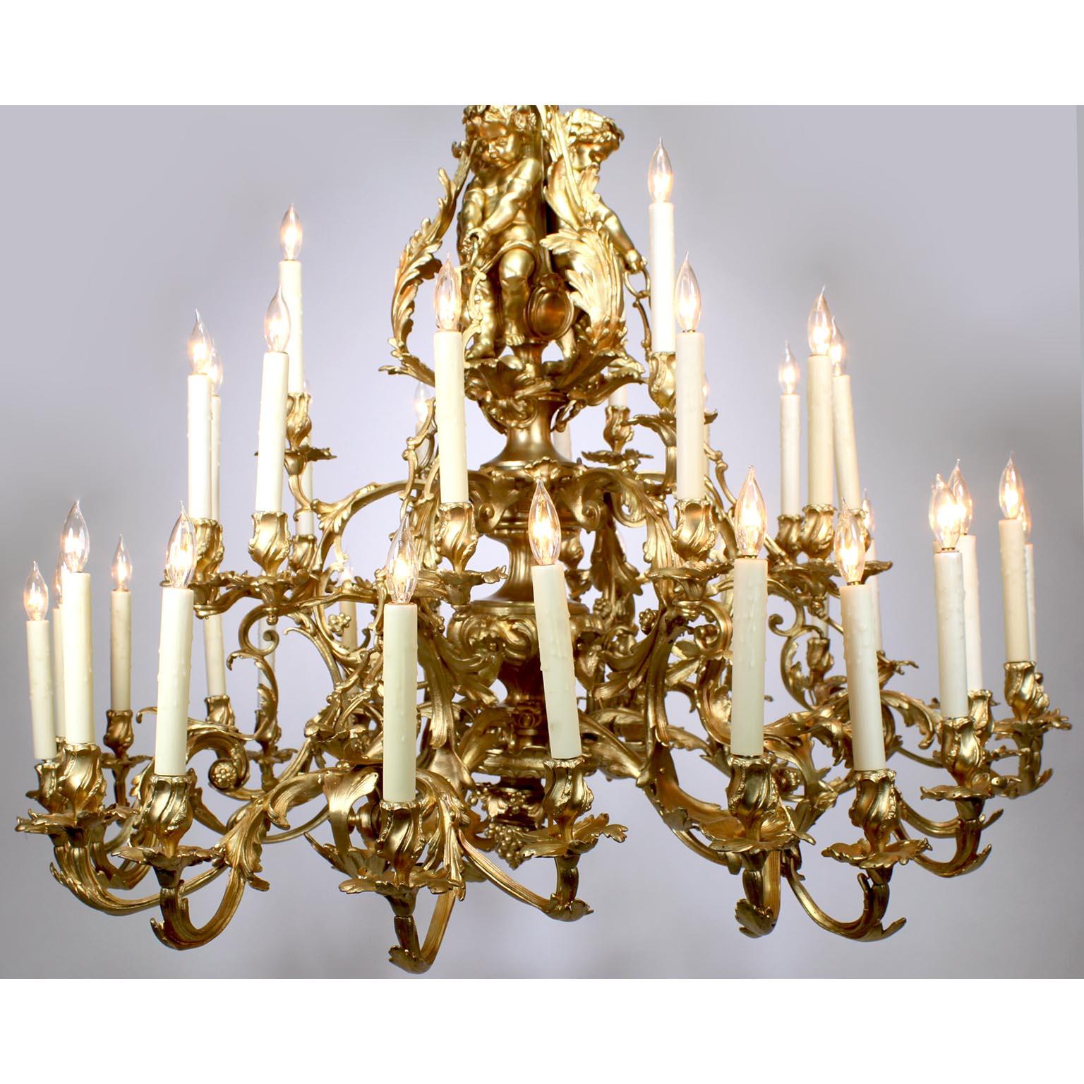 A Palatial French 19th Century Louis XV Style Gilt-Bronze Figural Thirty-Nine Light Chandelier. The scrolled arm candle-arms designed with acanthus and floral wreaths protruding from a center stem surmounted with three allegorical standing Putti