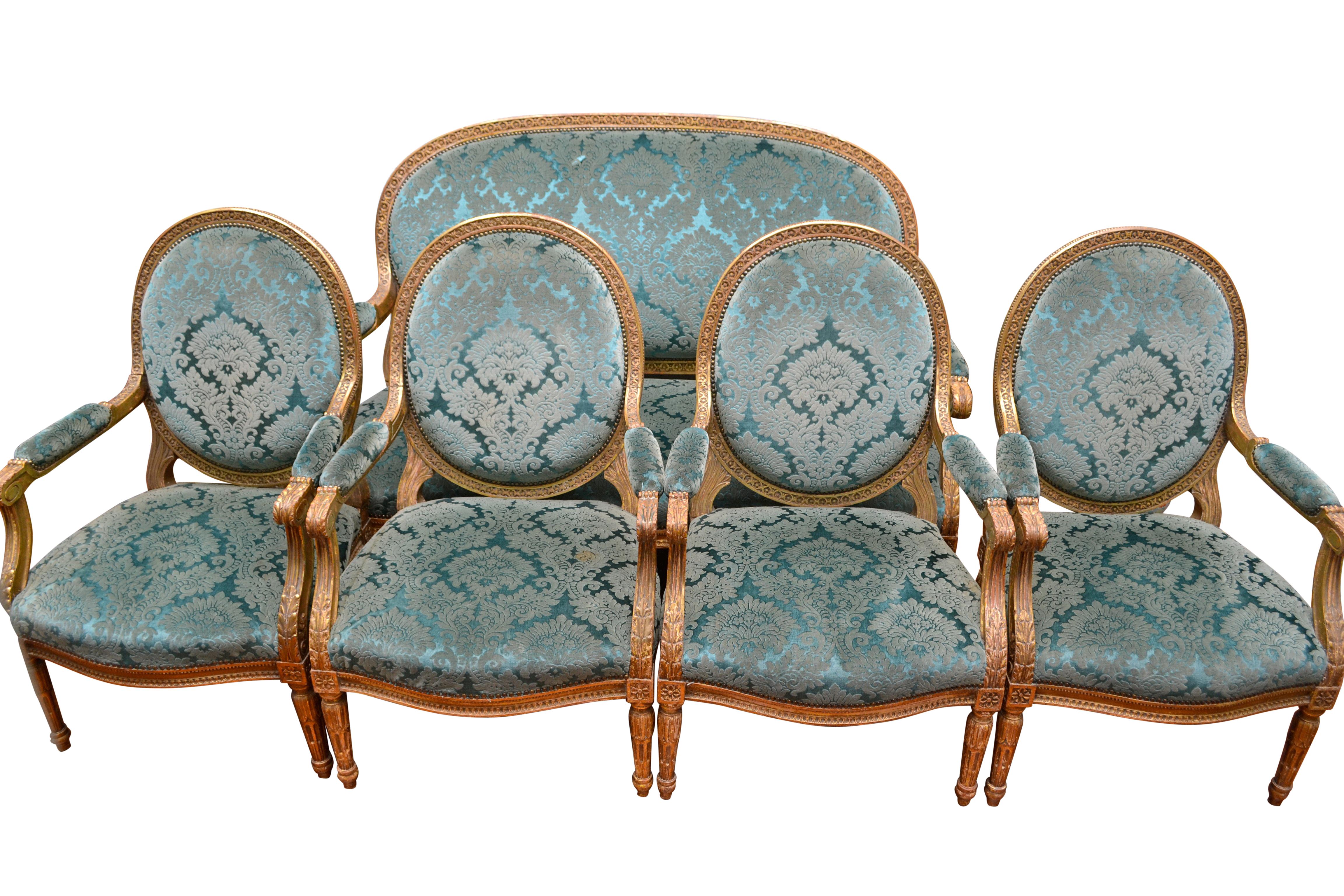 A palatial scale Louis XVI style salon set comprising four arm chairs and a matching sofa. The deeply carved frames are finished in gold leaf and upholstered in antique turquoise Italian silk velvet that originally hung as drapes in an English