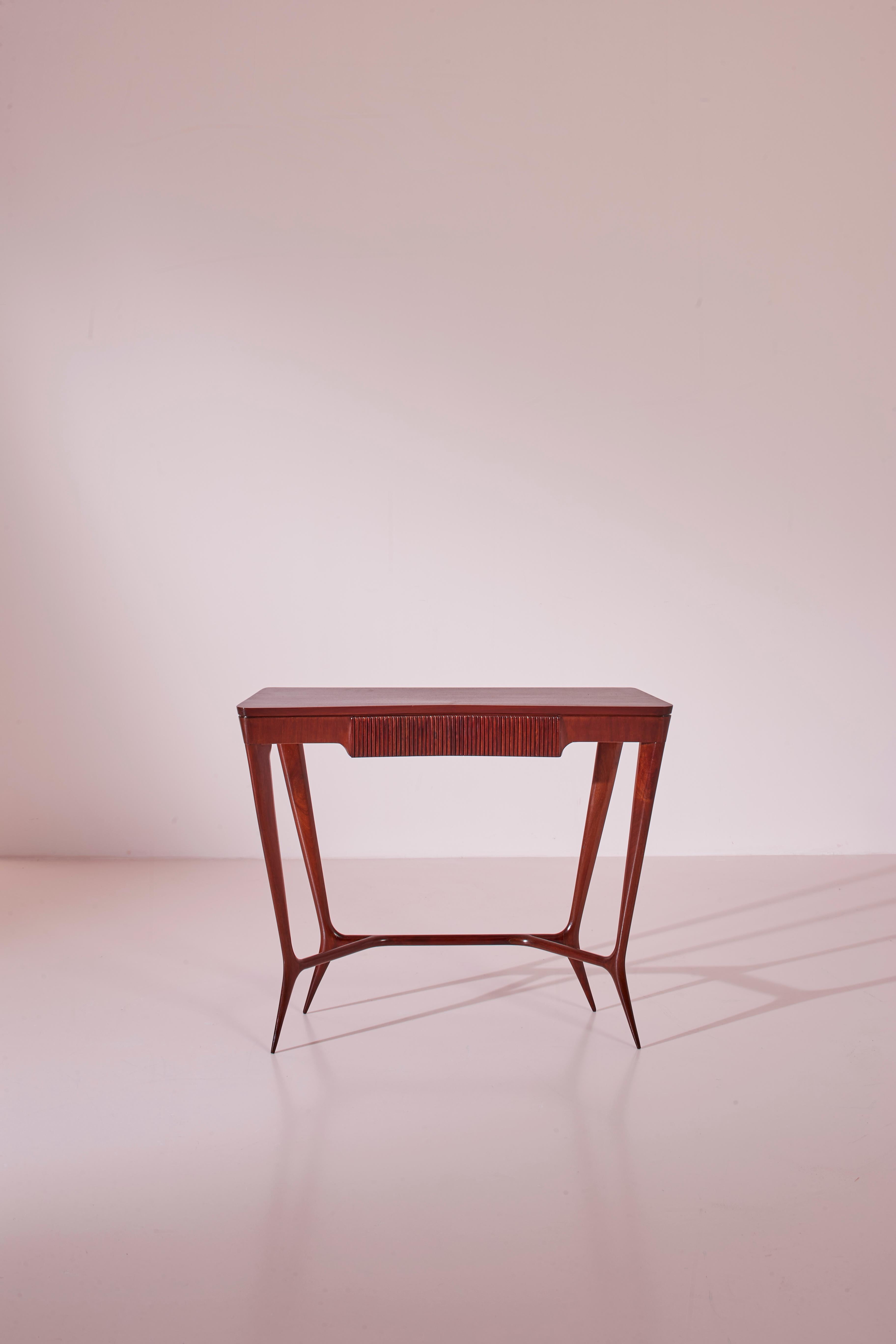 An elegant wooden console, the result of Italian craftsmanship from the 1950s. Produced in Cantù by master craftsmen, this piece stands out for its refined design and meticulous details. 

The central drawer adds functionality without compromising