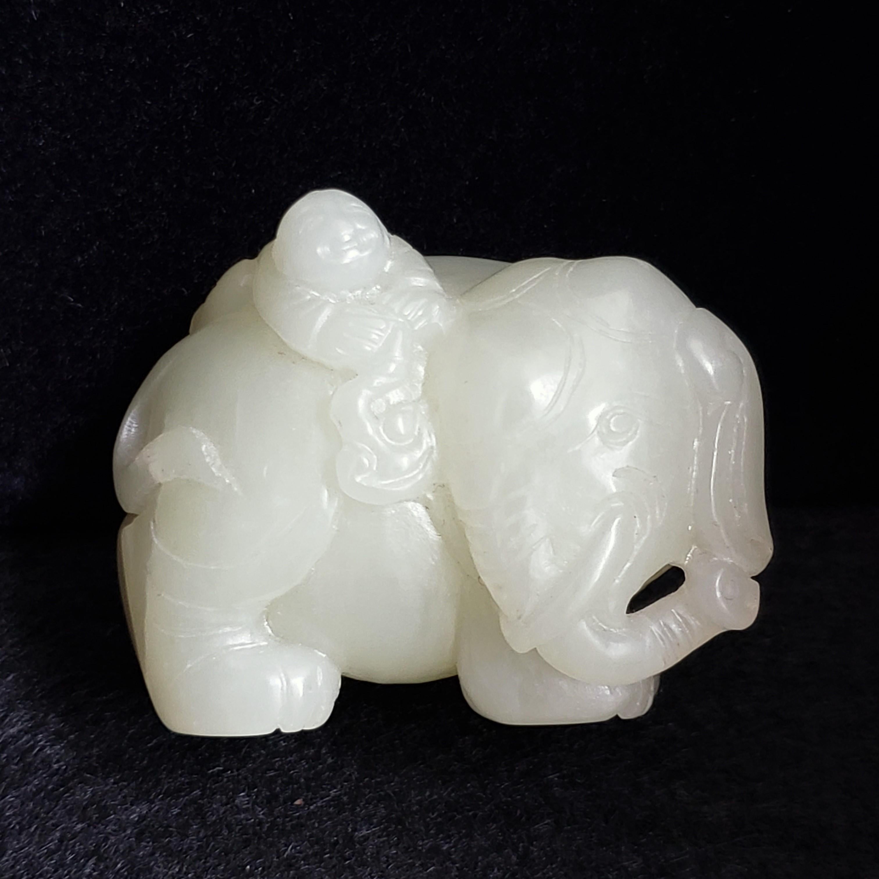 La figure d'un jeune garçon au sommet d'un éléphant géant a été sculptée en jade céladon pâle. Sa tête et sa queue sont tournées d'un côté. Sa trompe passe à travers les défenses et s'étend jusqu'à toucher son oreille.

Le garçon chauve et rieur se
