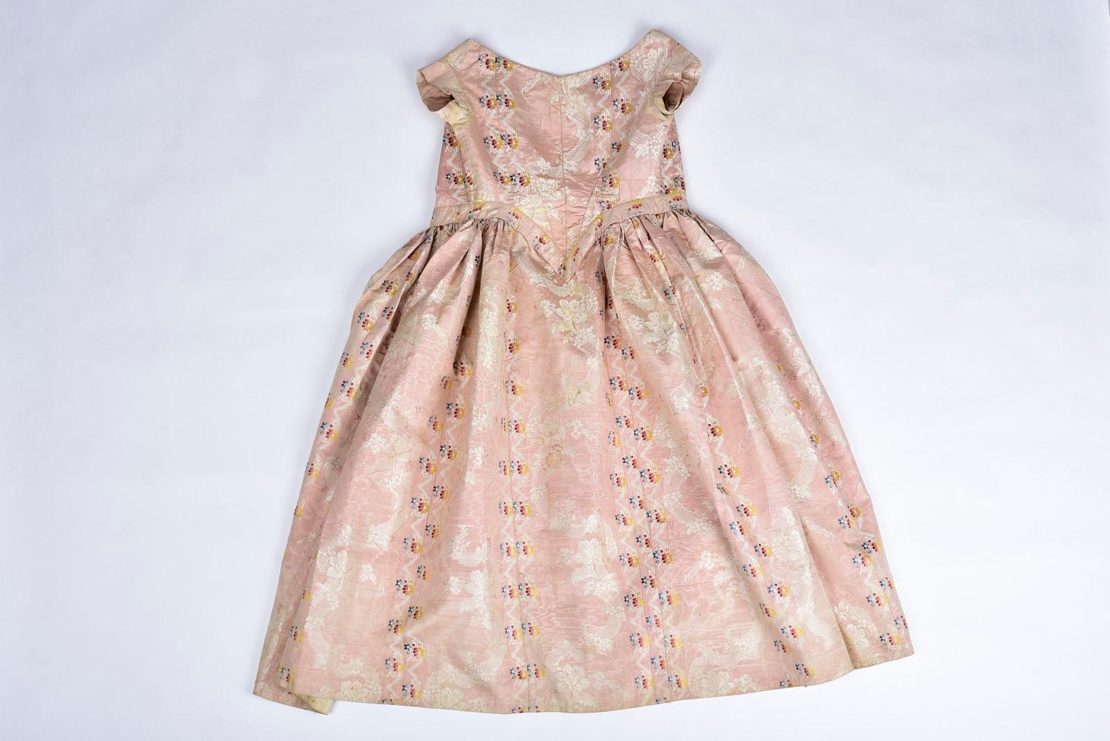 Circa 1860
France or Southern Europe

Beautiful summer crinoline ball gown in pale pink moiré silk lampas with brocaded floral garlands, probably made earlier than the large crinoline dress. The one-piece bodice is whalebone, pointed at the front