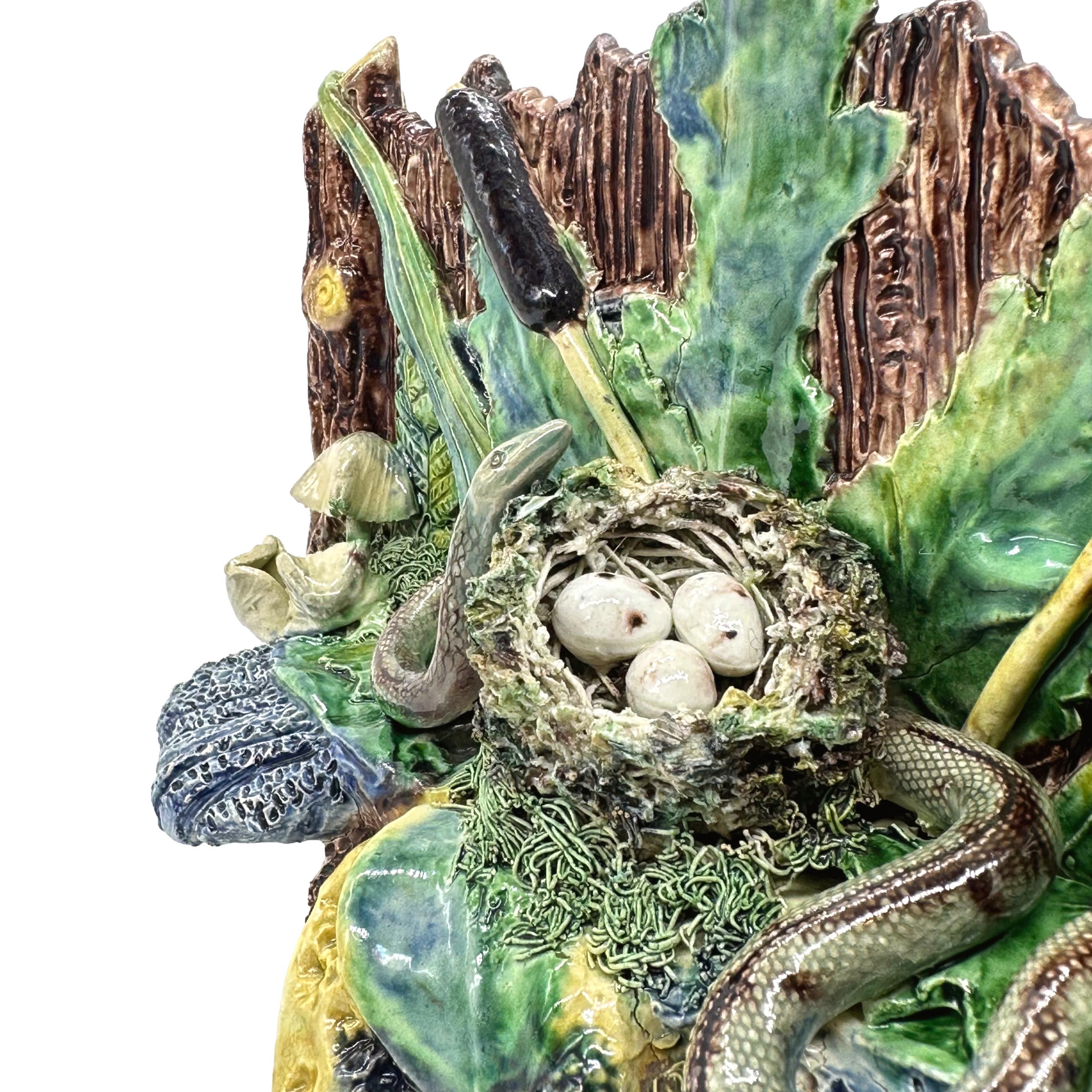 A Palissy Ware Majolica Jardinière, modelled as a rectangular rustic wooden trough with simulated wooden staves and branches, with ferns and green-glazed foliage, bullrushes, and toadstools on a mossy rockwork base, surmounted by a bird's nest of
