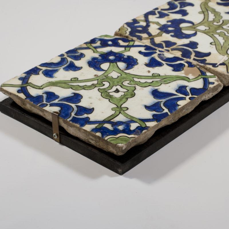 A panel of two square Ottoman Empire ‘Dome of the Rock’ tiles, painted in underglaze cobalt blue, black and apple green with a trellis of split and winged palmettes with cloud-scroll collars.  Syrian, 16th century.

Provenance:  Property of a