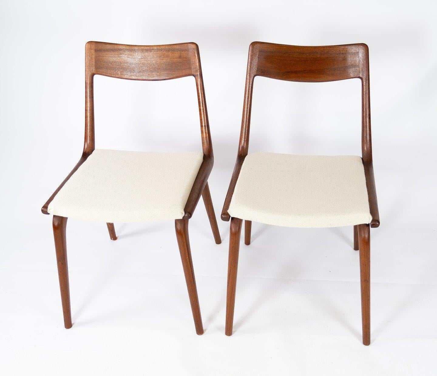 A papir of dining chairs, model Boomerang, in teak and light wool fabric designed by Alfred Christensen from the 1960s. The chairs are in great vintage condition.