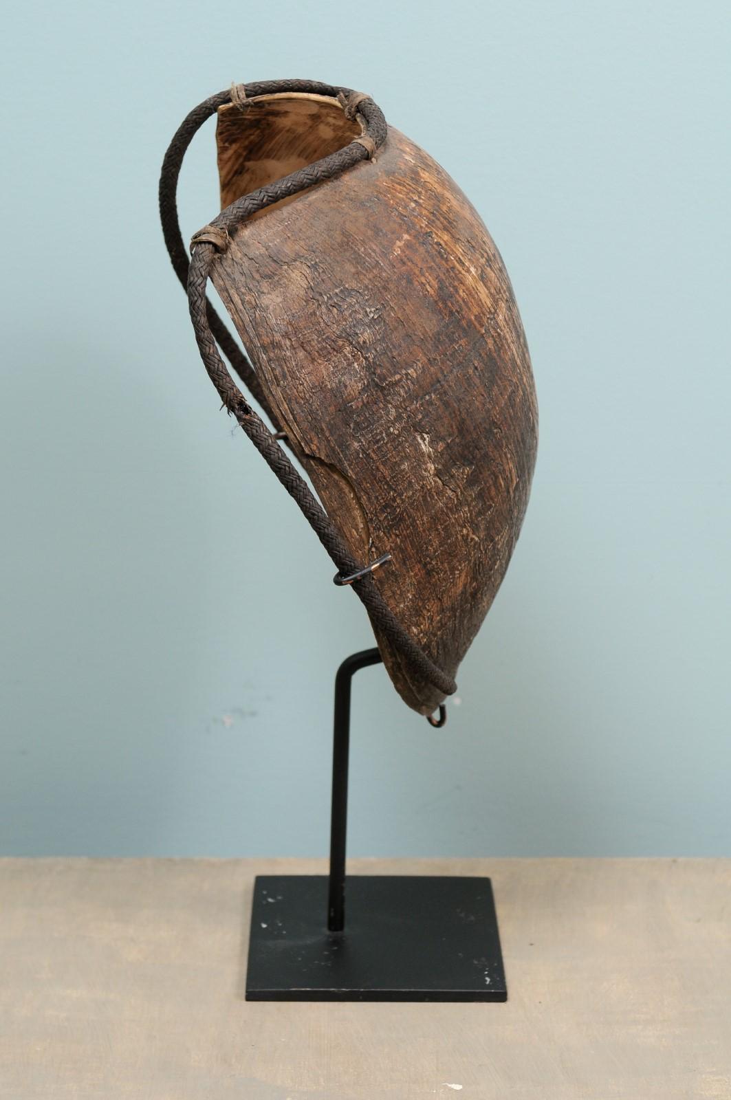 A Papua New Guinea highlands bailor shell breast plate from the mid-20th century on custom stand. This beautiful oceanic tribal art piece is a bailer shell and would adorn the pectoral or chest as a breast plate of male warriors of the Mendi People,