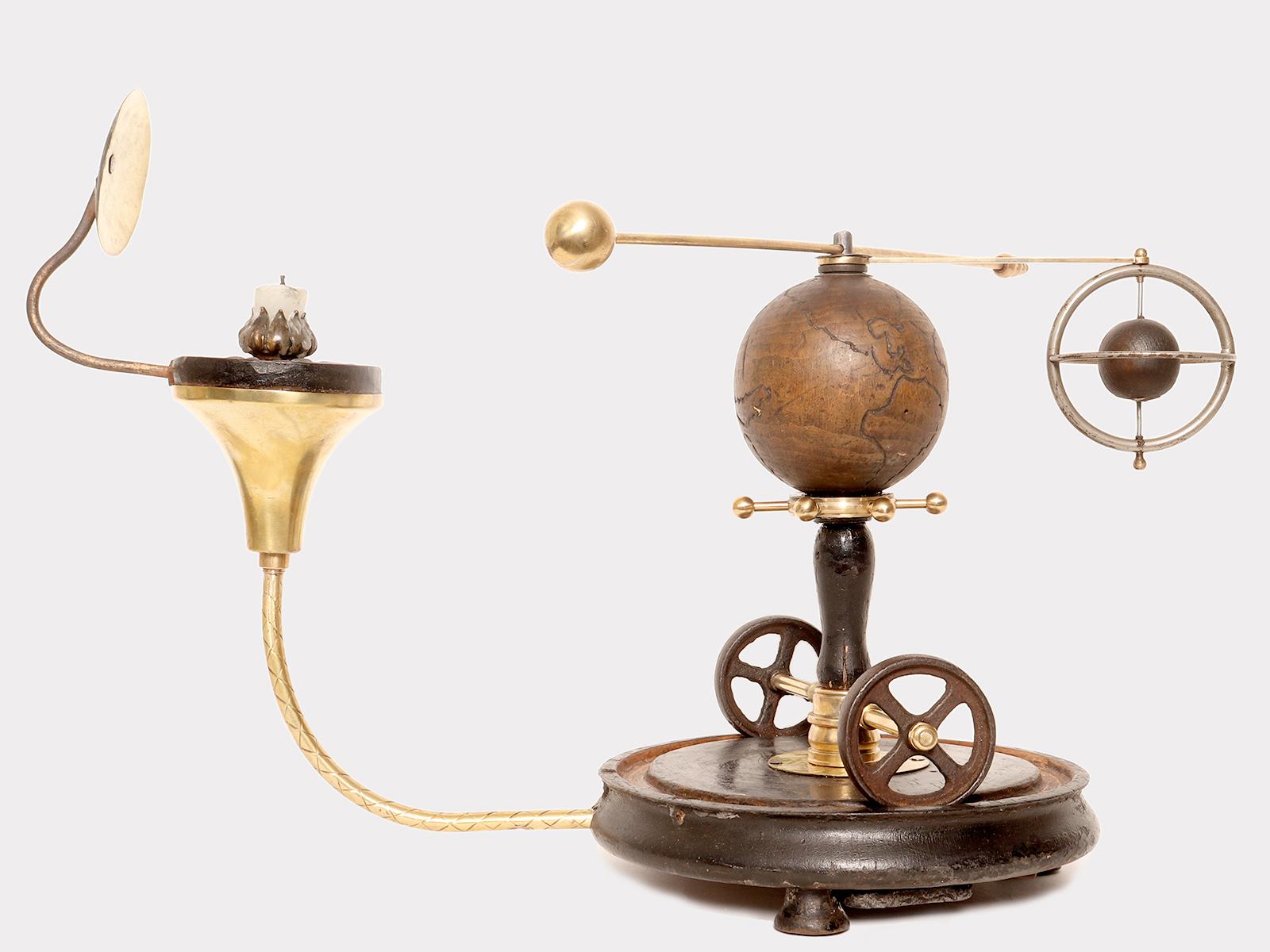 Une orrerie paradoxale qui démontre le système terre-lune et son mouvement. La base du planétarium est en bois fruitier, de forme circulaire avec trois pieds en bois en forme de cloche. Le profil de la base est ondulé, le sommet est plat et présente