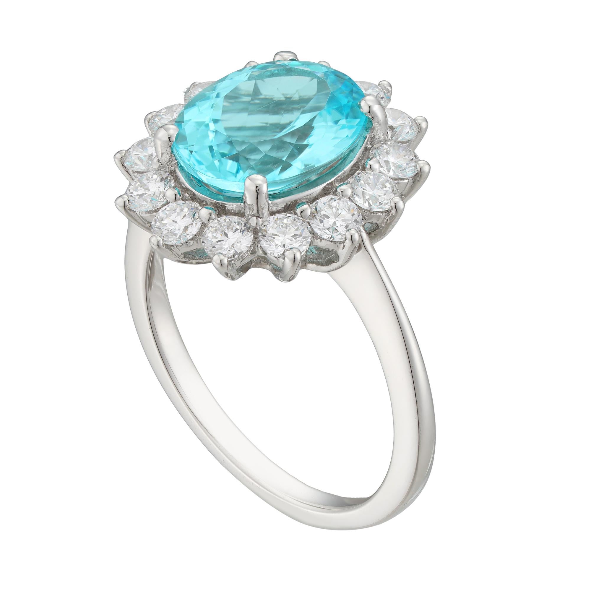 A Paraiba tourmaline and diamond cluster ring, the oval-shaped brilliant-cut tourmaline weighing 3.36 carats accompanied by GCS report stating the origin to be of Mozambique, four claw-set and  surrounded by fourteen round brilliant-cut diamonds