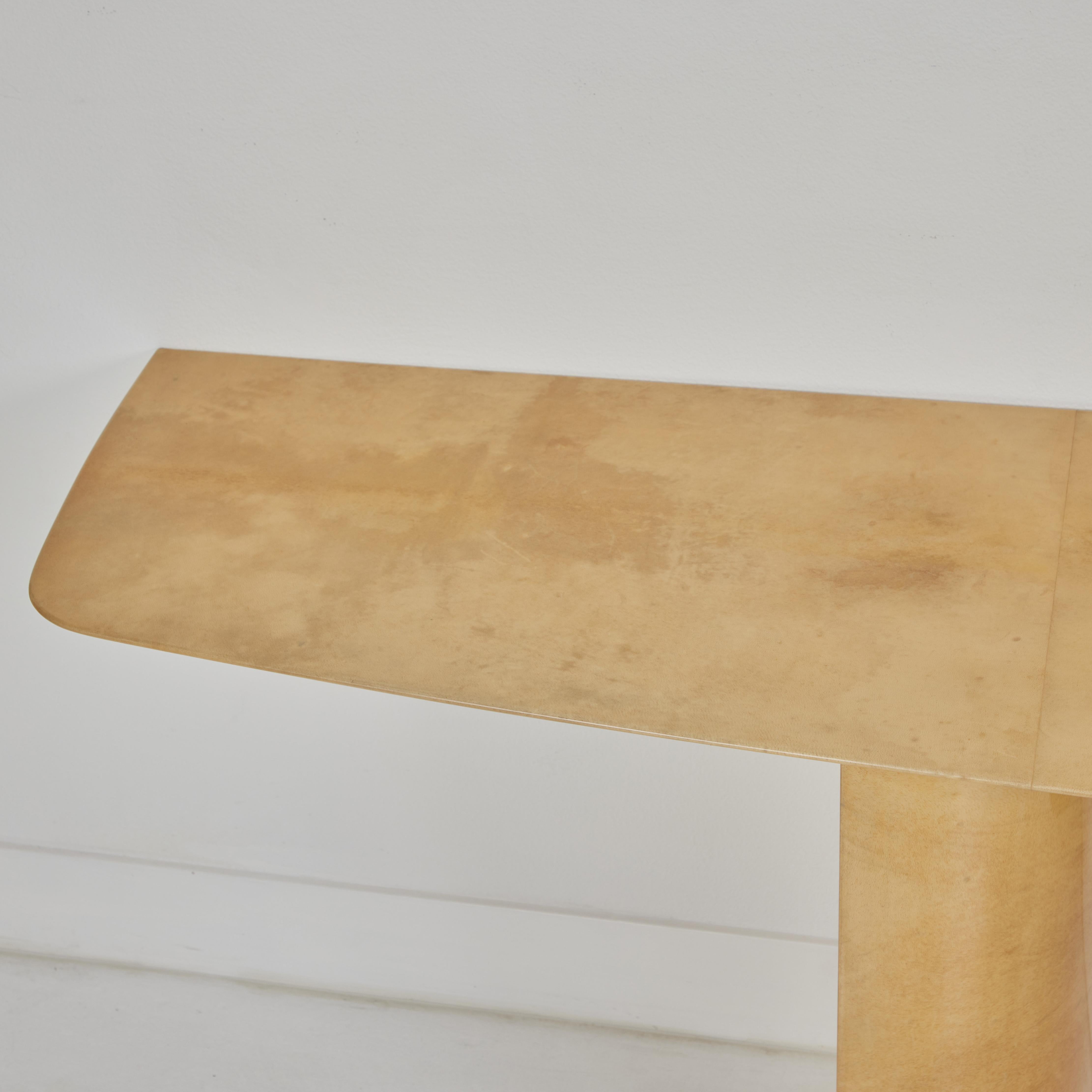 Il s'agit d'une table console magnifique et élégante, conçue et fabriquée par Aldo Tuna, une société italienne réputée pour son travail sur le parchemin.  La table présente un superbe bord biseauté sur le plateau qui repose sur deux colonnes dont le