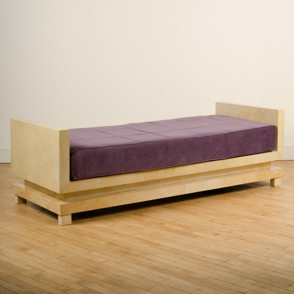 A parchment covered daybed in the manner of Jean-Michel Frank with purple upholstered cushion. Contemporary.