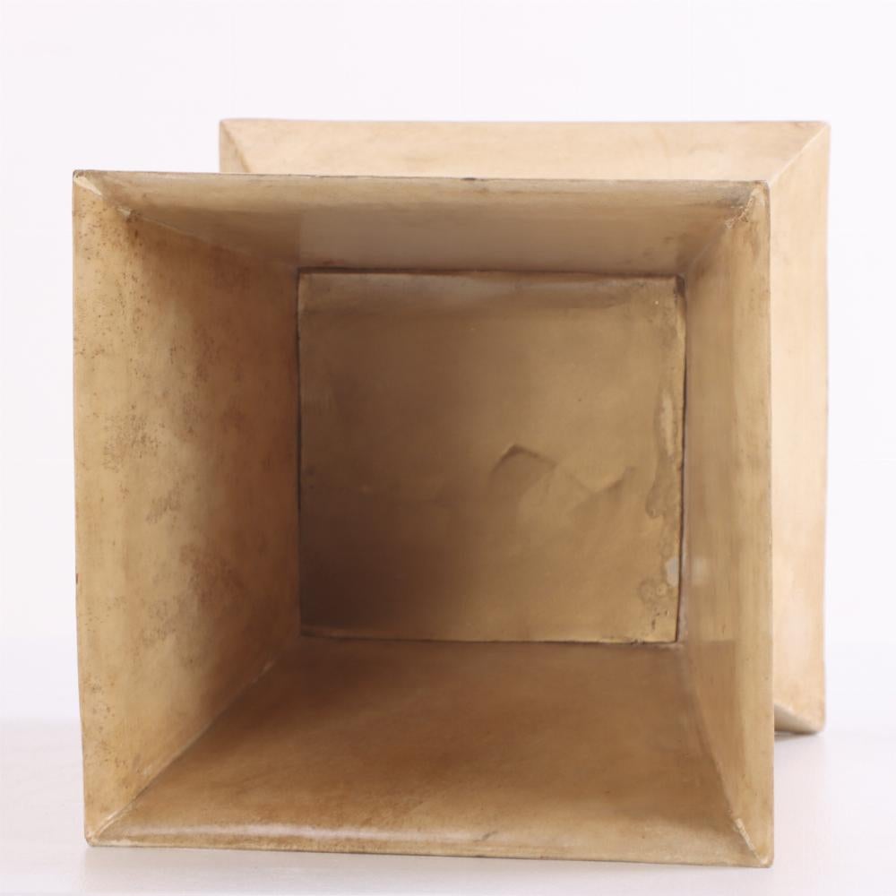 Le panier présente une silhouette sculpturale et géométrique enveloppée dans un parchemin teinté à la main. Le design angulaire confère un accent de présence architecturale à votre intérieur, tandis que la finition parchemin offre une texture douce