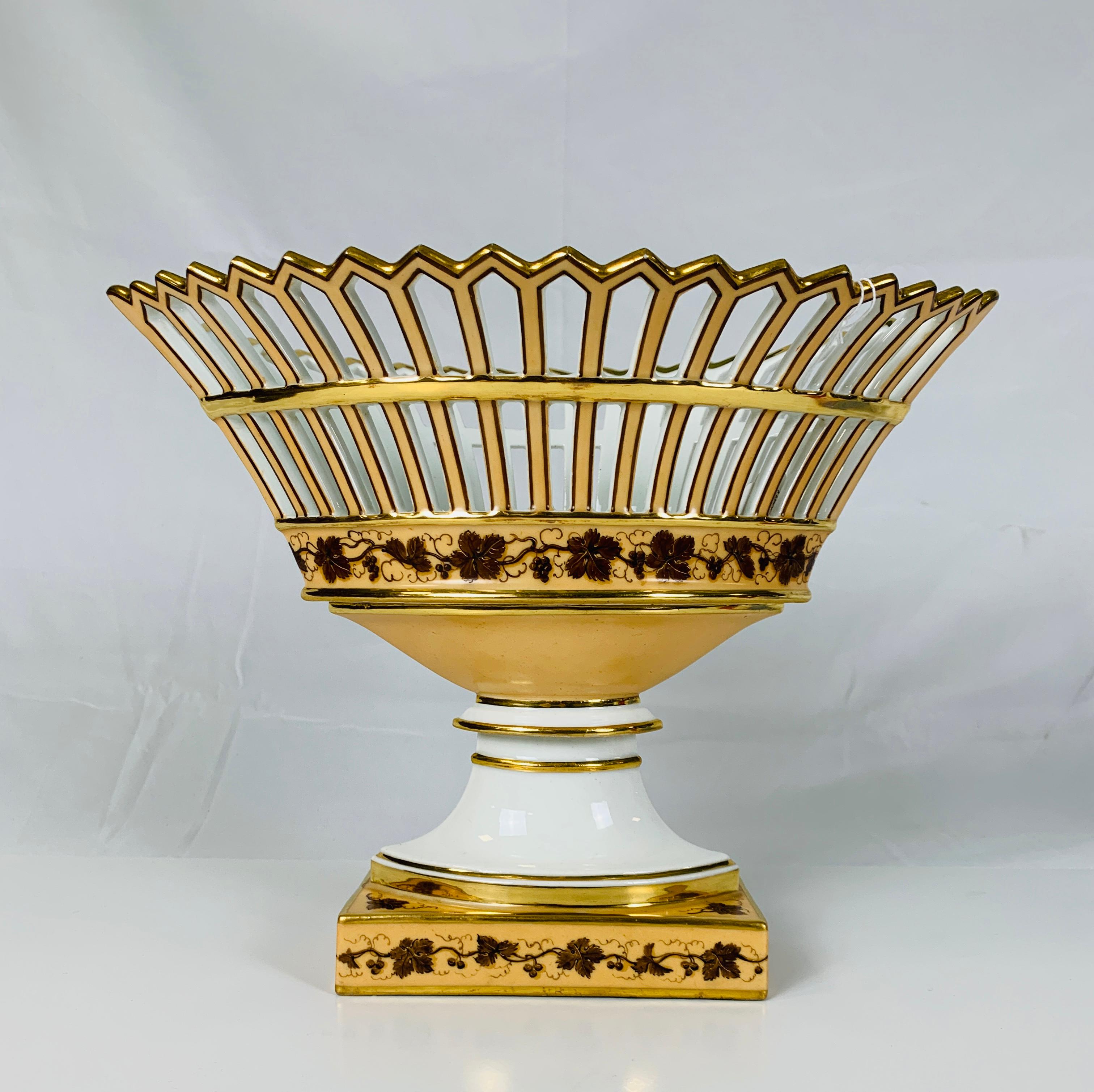 A set of three French Paris Porcelain baskets comprising an oval-shaped centerpiece and a pair of matching round baskets all decorated with brown grape leaves on a light caramel ground. The exquisite neoclassical grape leaf design gets its