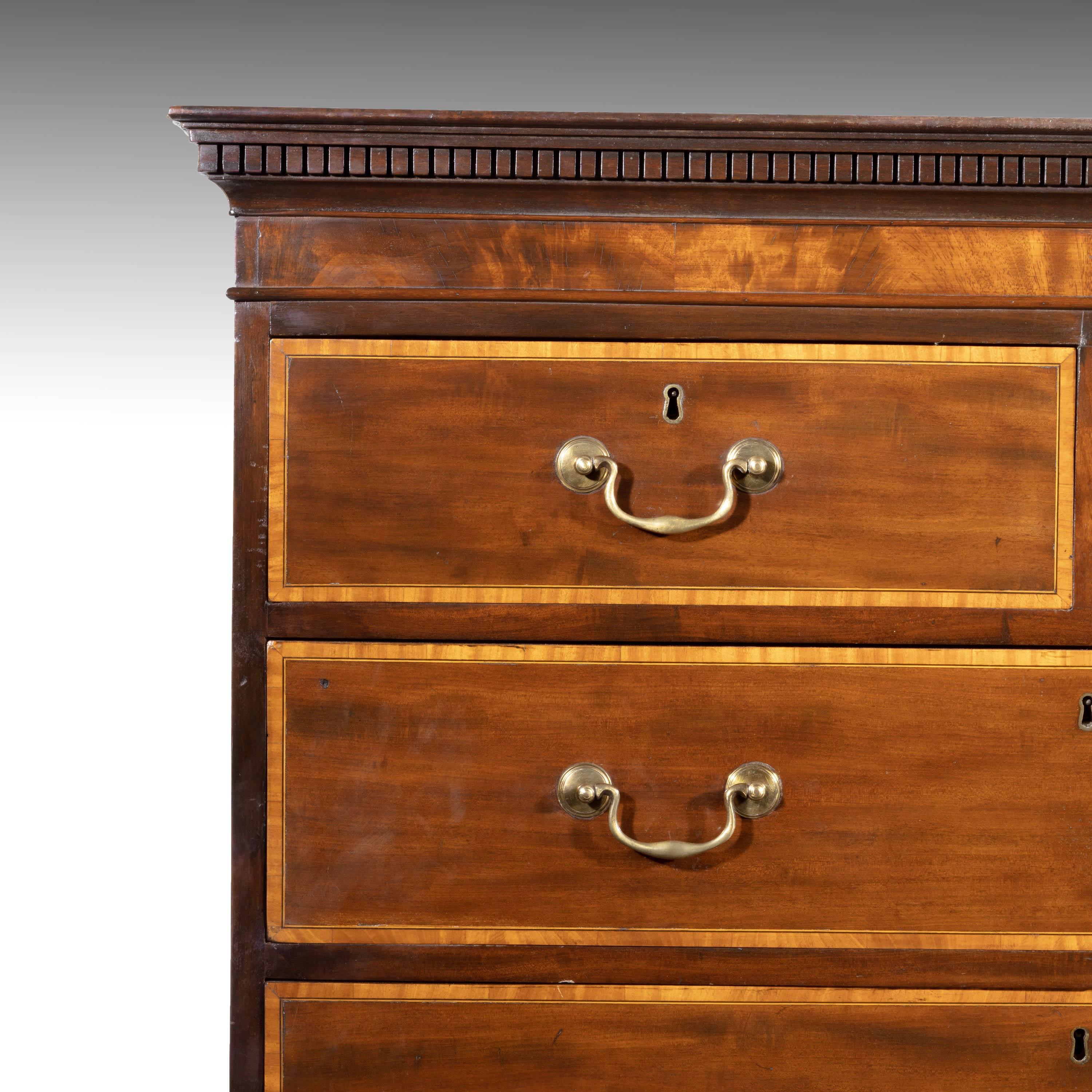 A particularly fine George III period mahogany chest on chest. All the drawer fronts beautifully edged in crossbanded satinwood. The top with a dentil cornice. Original high bracket feet and particularly fine original gilt bronze handles, still