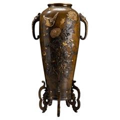 A patinated bronze baluster vase with rich inlays and naturalistic motifs