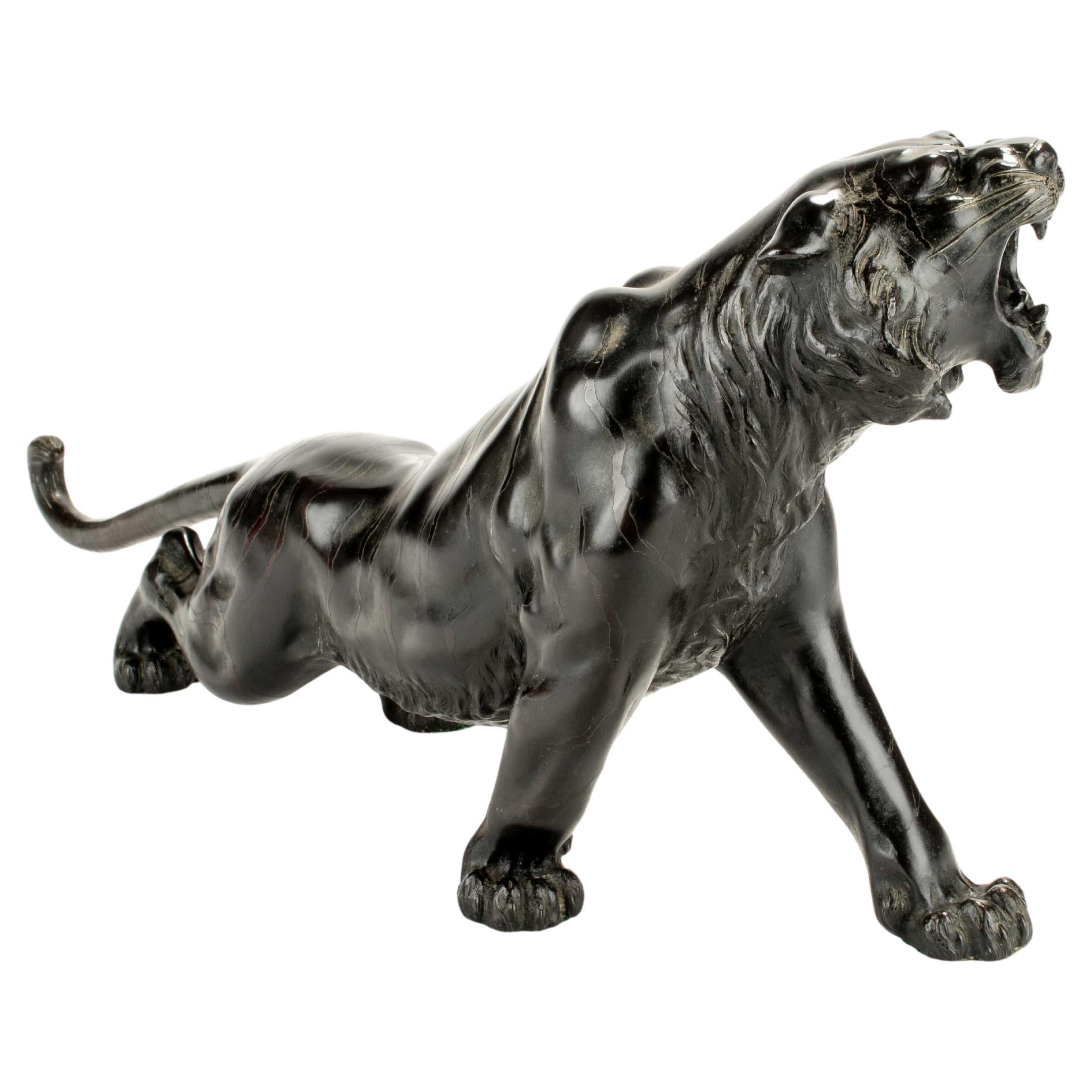 A patinated bronze okimono of a roaring tiger, signed Maruki Company and Atsuyos
