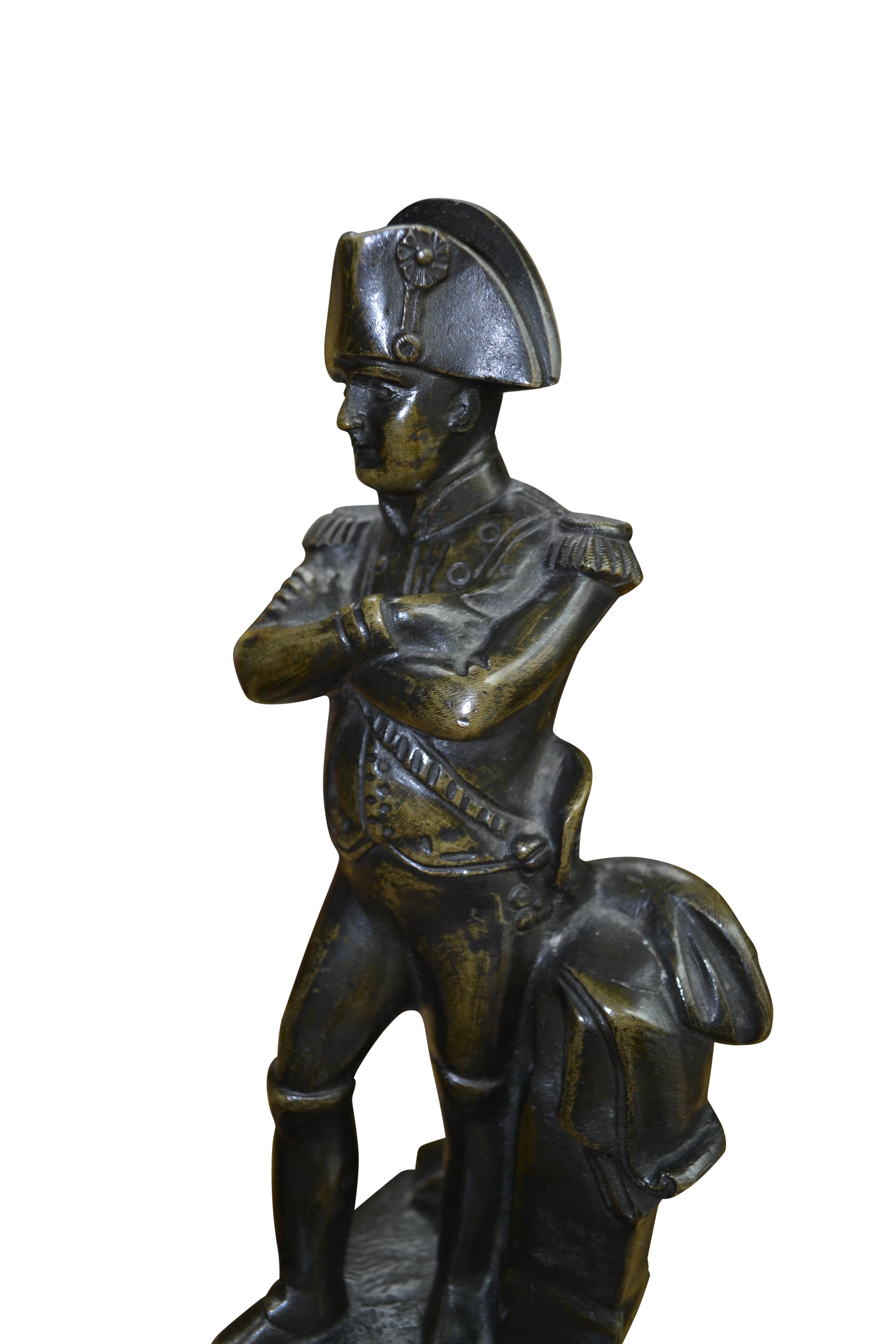 Un piccolo cast solido  statua in bronzo ben patinato di un Napoleone in piedi in uniforme che incrocia le braccia e indossa il suo iconico cappello a bicorne secondo un modello  dello scultore francese della fine del XIX secolo Émile Guillemin