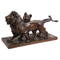 A Patinated Bronze Sculpture of Two Striding Lions, Signed By the Artist