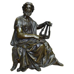 Una estatua de bronce patinado  de un erudito clásico sentado Firmado  Doriot