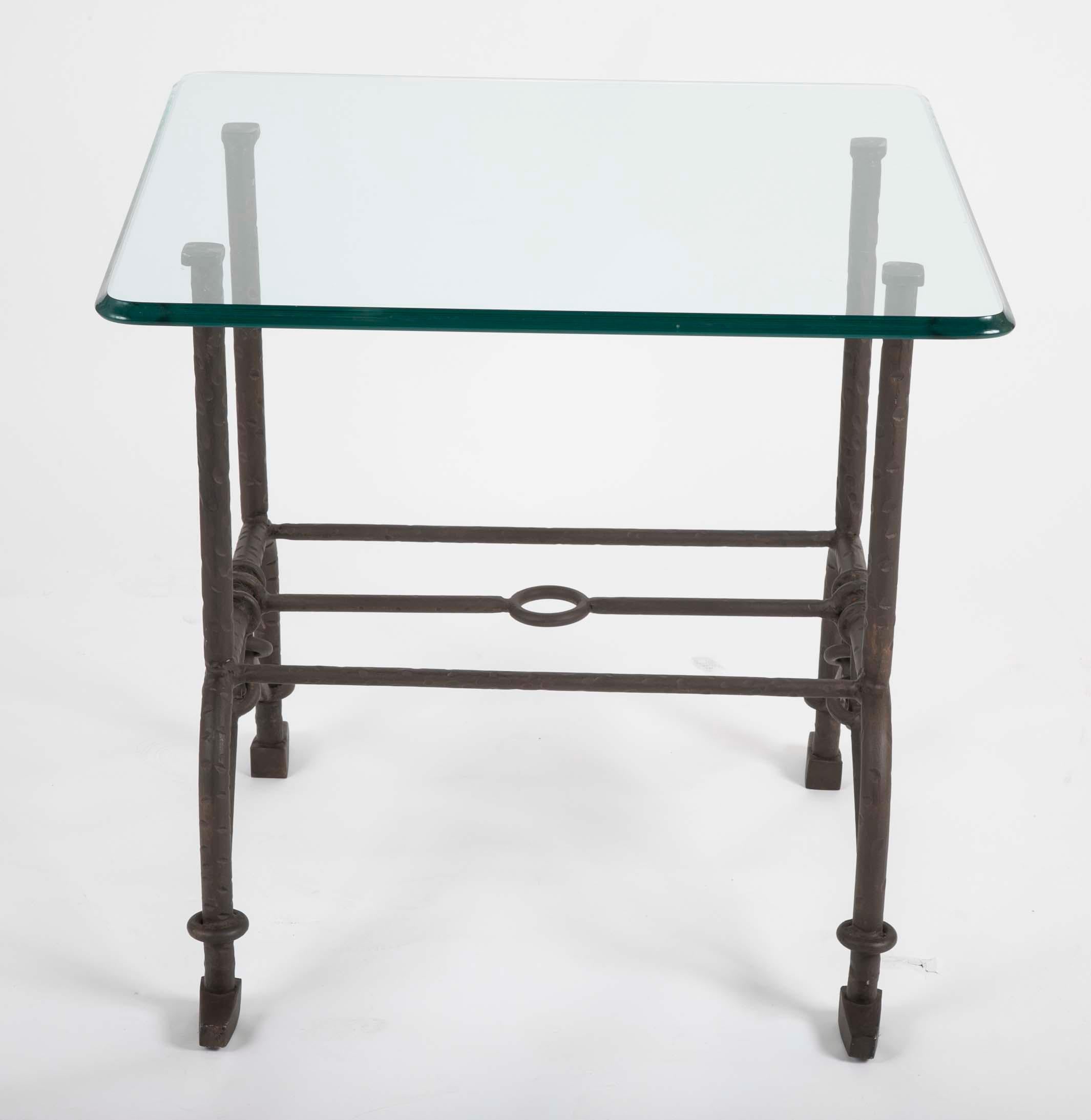 A Glass top patinated steel side table in the style of Giacometti.