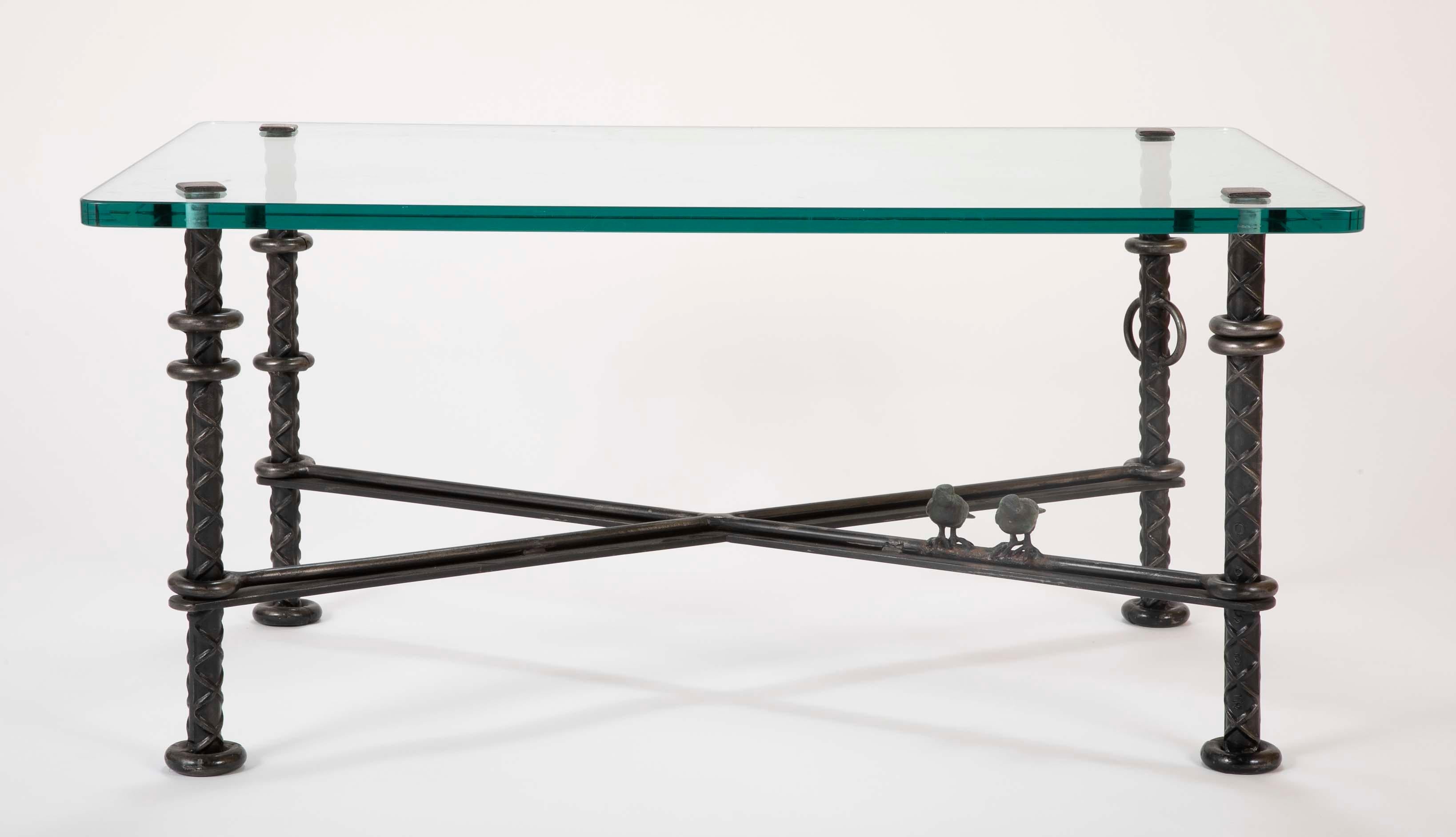 A magnificent patinated wrought iron coffee table by Llana Goor having two figurative sculpted birds. Signed on leg.