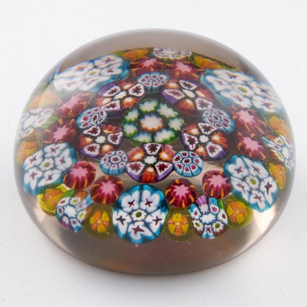 A Paul Ysart Concentric Complex Millefiori Magnum Paperweight, c1950

Additional information:
Date : c1950
Origin : Scotland
Features : A three row concentric weight with complex canes on a clear ground.
Marks : none
Type : Lead
Size : Diameter 8.75