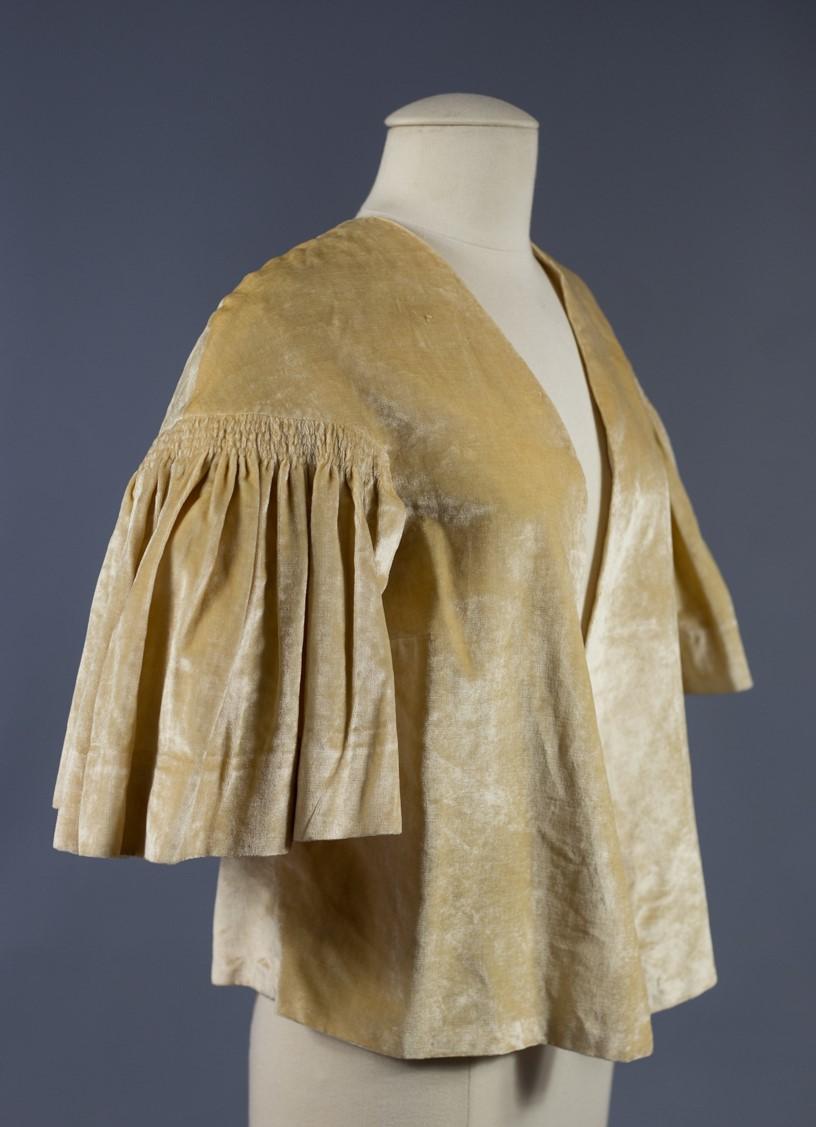 Circa 1930/1940
France
Evening bolero in iridescent velvet with a peach skin effect dating from the 1930s / 1940s, in the same style as Jeanne Lanvin's production at the same period.. Flared cut, without collar, buttons or fasteners and lining in