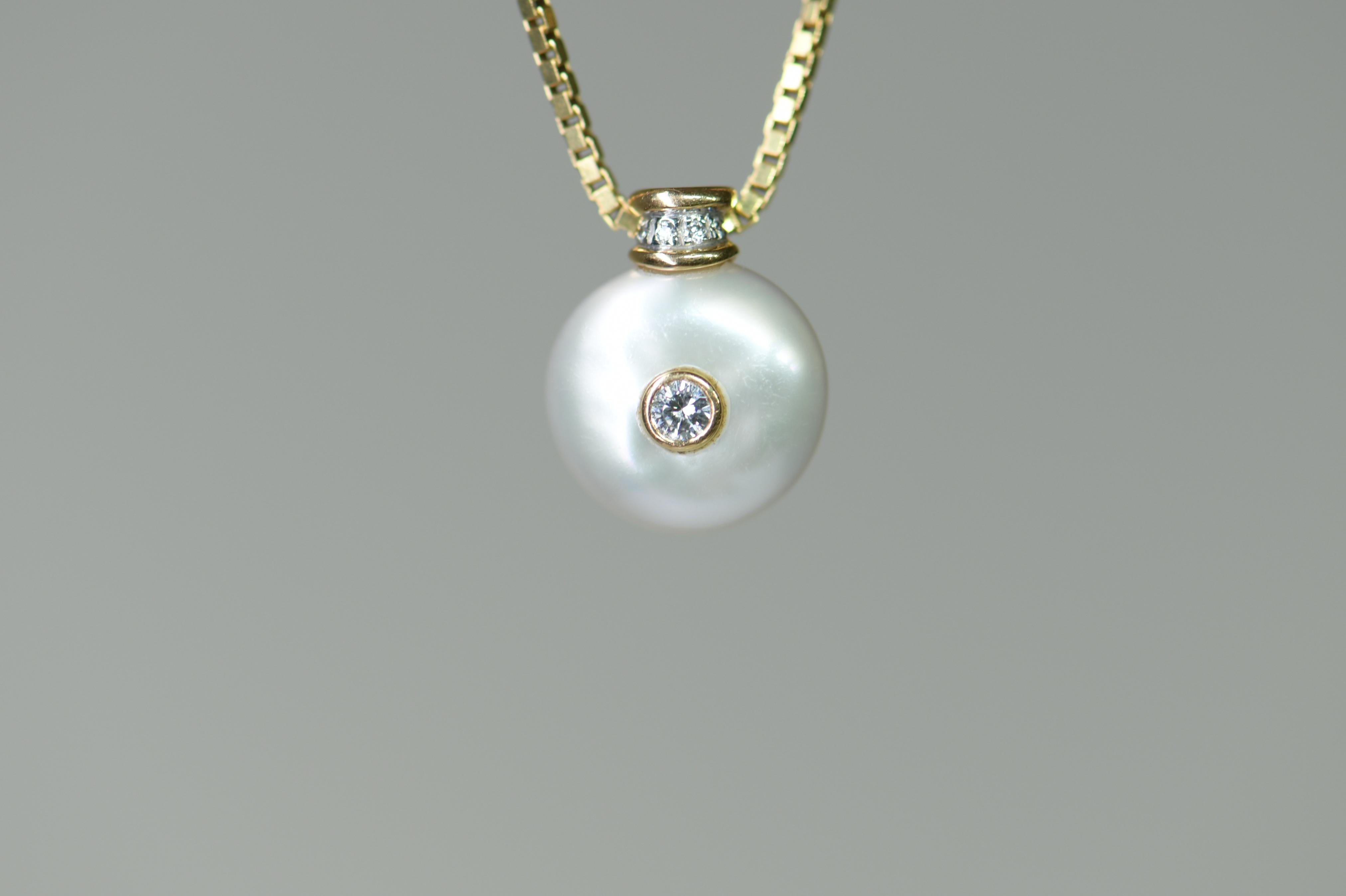 A Pearl And Diamond Pendant set with bouton pearl, collet set to the center with a small round brilliant-cut diamond, the pendant to a link chain, stamped 750.

STONES
Pearl: 12 in diameter 
Brilliant Cut Diamonds: 0.25ct

Length: