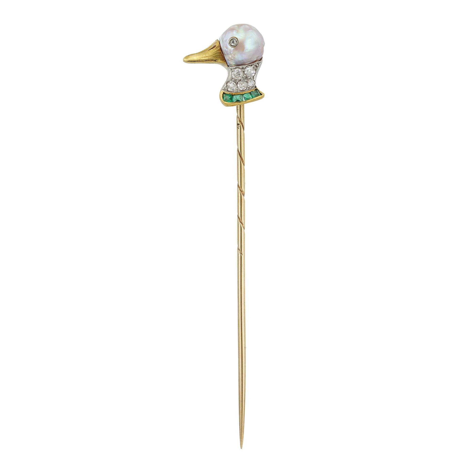 An Early 20th century pearl, diamond and emerald duck head stick-pin, the head of the duck formed of a baroque pearl, with a diamond inlayed eye, the beak made of yellow gold, the collar set with five old-cut diamonds and four calibre-cut emeralds,