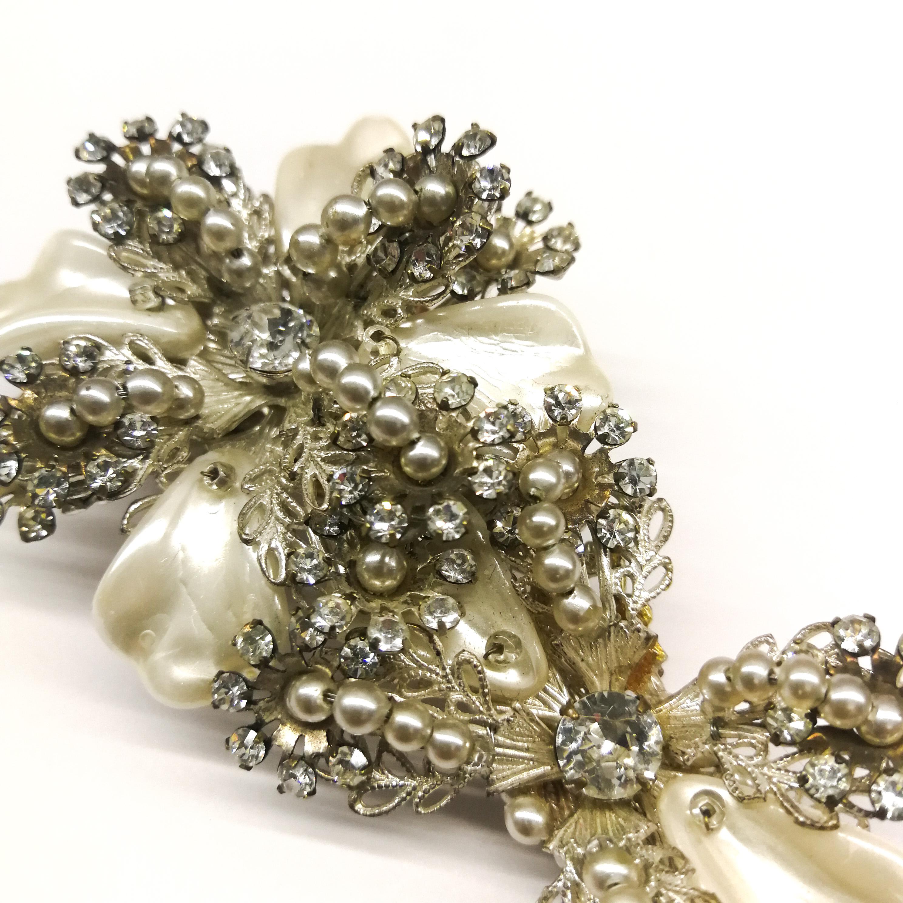 An unusual and very stylish brooch, designed by Robert Clark for Miriam Haskell. Its most enchanting feature are the baroque mother of pearl 'leaves', in the form of a stylised flower, all highlighted with small pearls and claw set clear pastes, all