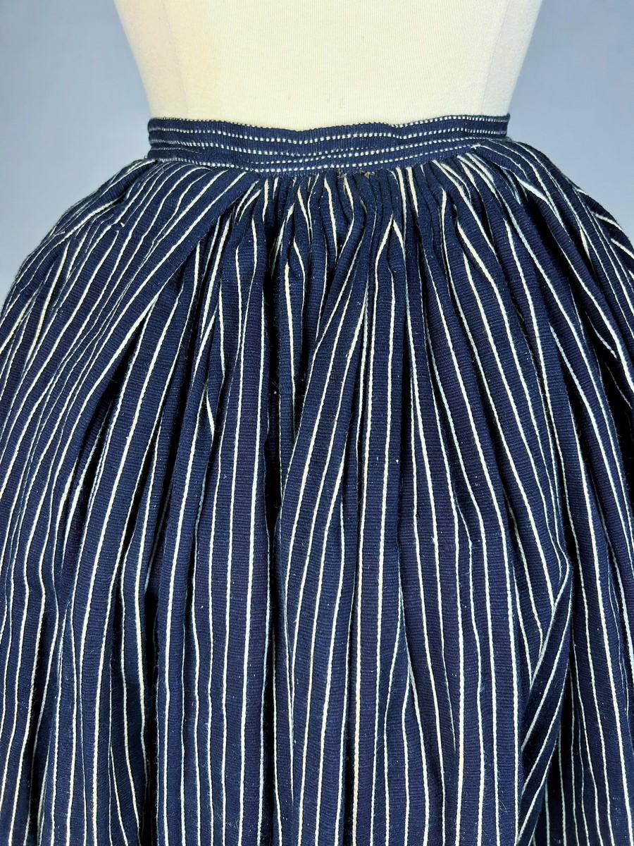 19th century

France Vendée or South West France

A peasant work skirt from the Vendée or the South West of France, in Indigo woven cotton/linen Siamoise with fine white stripes. Opening in the front and pleated back.  Matching waist belt in