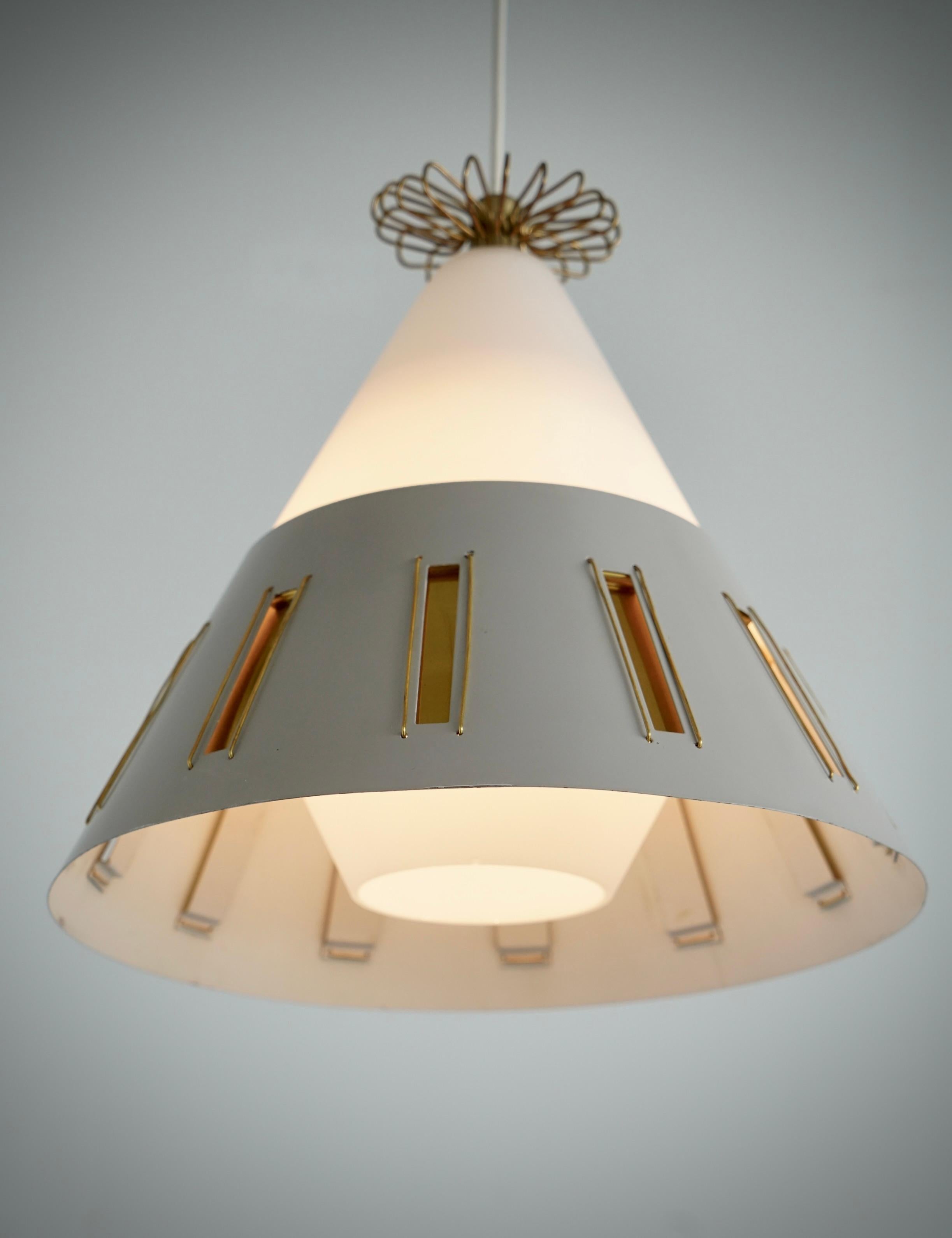 Un pedante dell'illuminazione progettato da Paavo Tynell e prodotto da Idman per Lightolier. Circa 1955.
Paralume in vetro smerigliato con coppa da soffitto in metallo laccato e ottone lucido. Dimensioni: H. 12