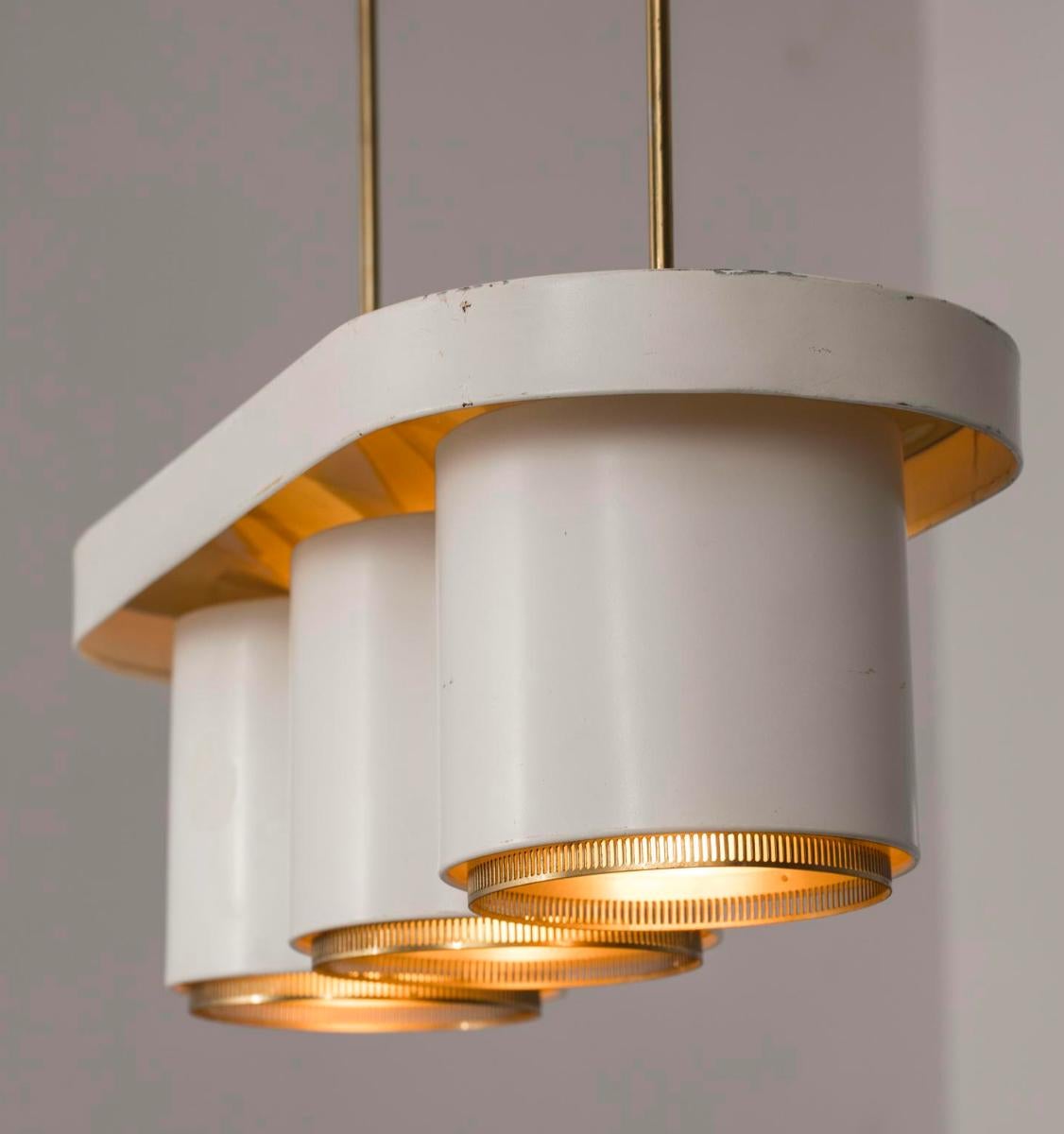 A pendant designed by Alvar Aalto to Valaistostyo Ky, Finland. Model A-203, Circa 1950th.
Lacquered metal with brass elements. Stamped by manufacturer. 
Existing wires, rewiring available upon request.