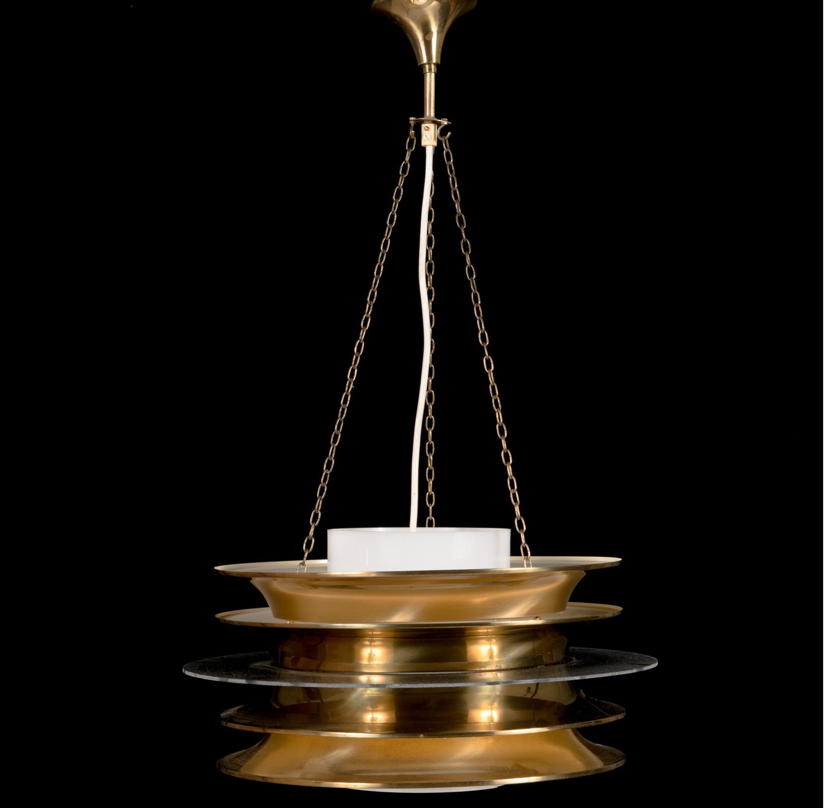 A pendant light designed by Kai Ruokonen ( Kai Finnmark) for Lynx, Finland. 1952.

Brass sheeted lamella lamp, smoke acrylic inner shade. Chain suspension with adjustable height. Label marked. Diameter 45 cm, height of the shade 23 cm.
Rewiring