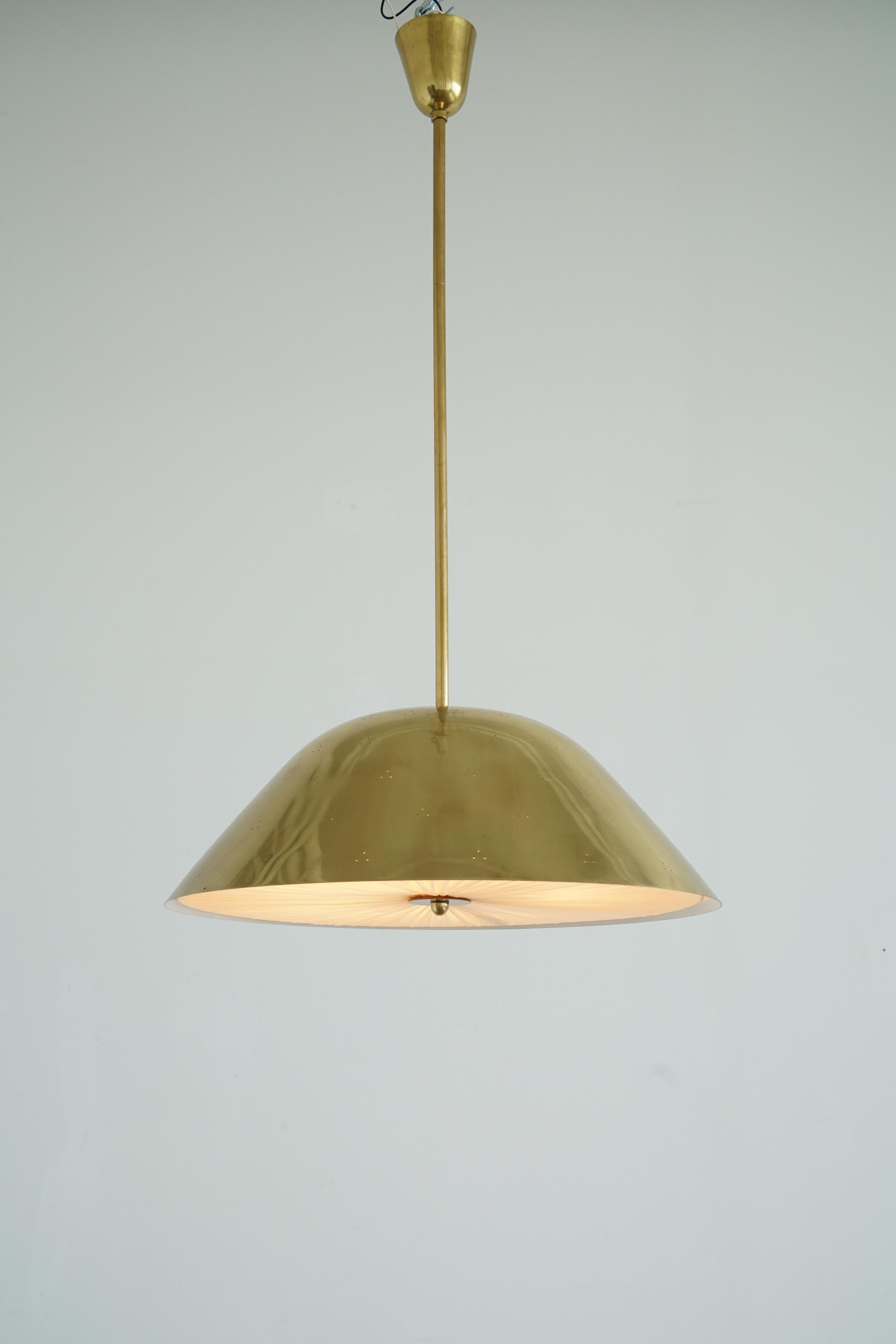 A pendant designed by Paavo Tynell for Taito Oy, Finland , circa 1950th.  Perforated brass shade with pleated silk defuser. Stamped ” TAITO”.  Existing wires, rewiring available upon request.
 H 40″ × Diam 20.5″. 