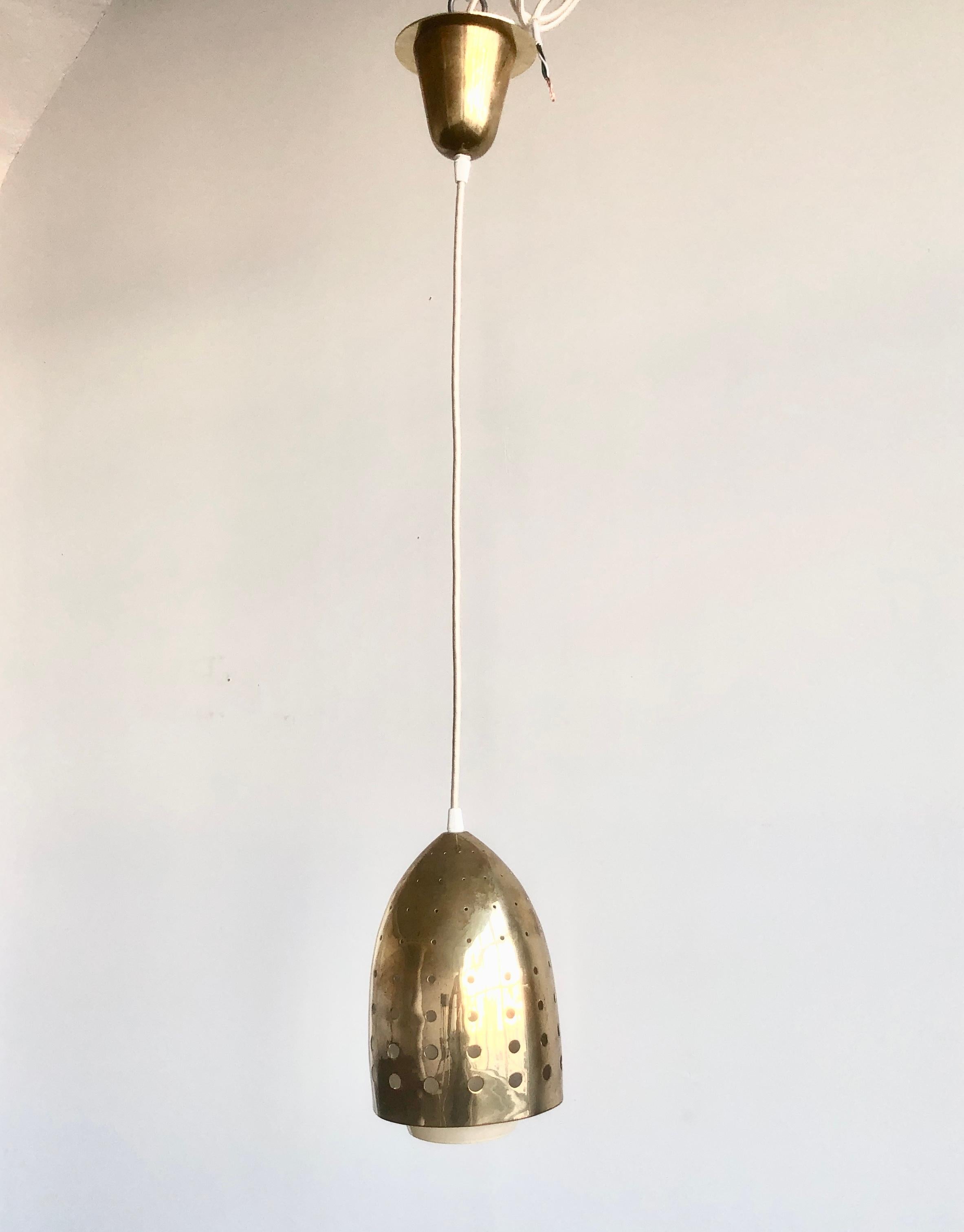 Lighting pendant designed by Paavo Tynell for Idman, Model number 51150, Finland , circa 1950th. Perforated brass shade with inner glass shade.
Newly rewired, overall drop 36