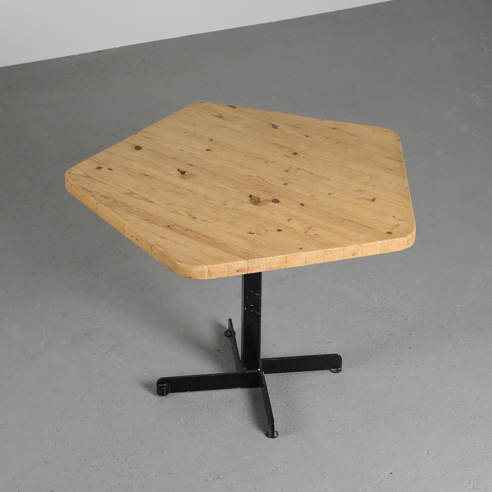This iconic table from Charlotte Perriand has a very nice patina.

Designed in the 70s for the furnishment of the Nova and the Lauzières residences in Les Arcs 1800 in the French Alps, it is made out of a laminated pine pentagonal top and a