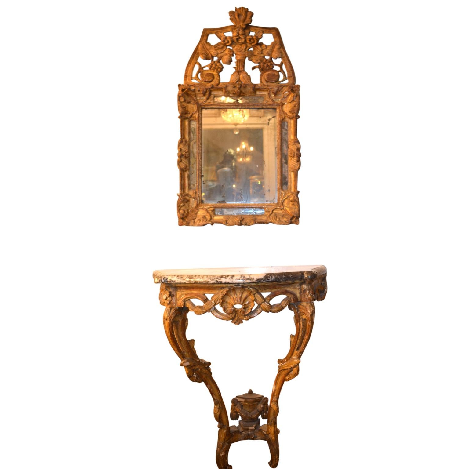 
A small period Louis XV carved and gilded beechwood console table, the palm entwined roccaille cabriole legs joined by a similarly carved stretcher crowned with carved swagged urn. The console is surmounted with a serpentine shaped grey and white