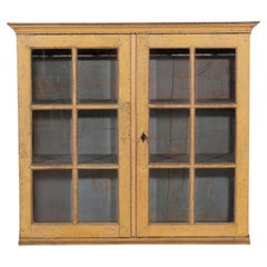 A period gustavian wall cabinet with glossed doors scraped to original paint