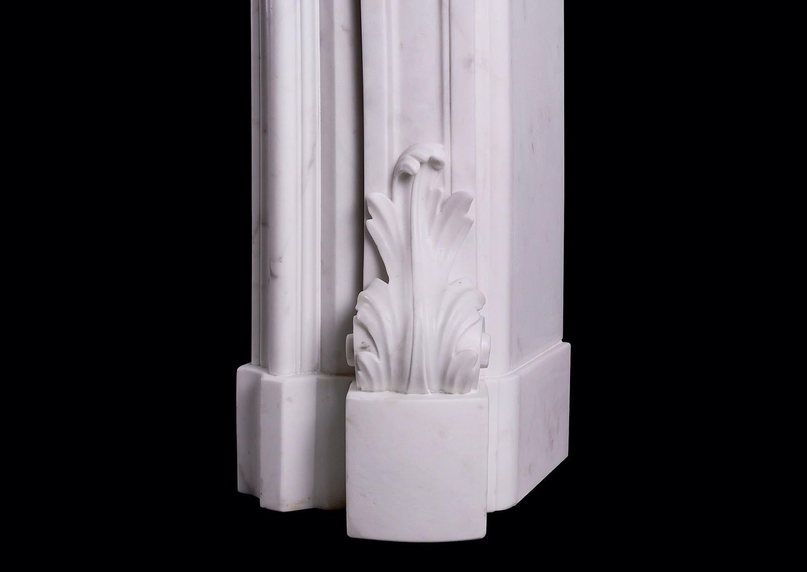 Cheminée de style Régence anglaise en marbre Statuaire de très belle qualité. Les jambages sont ornés de feuilles d'acanthe raides à la base, surmontées de boules, de feuilles d'acanthe et de rinceaux. La frise est ornée d'un cartouche sculpté au