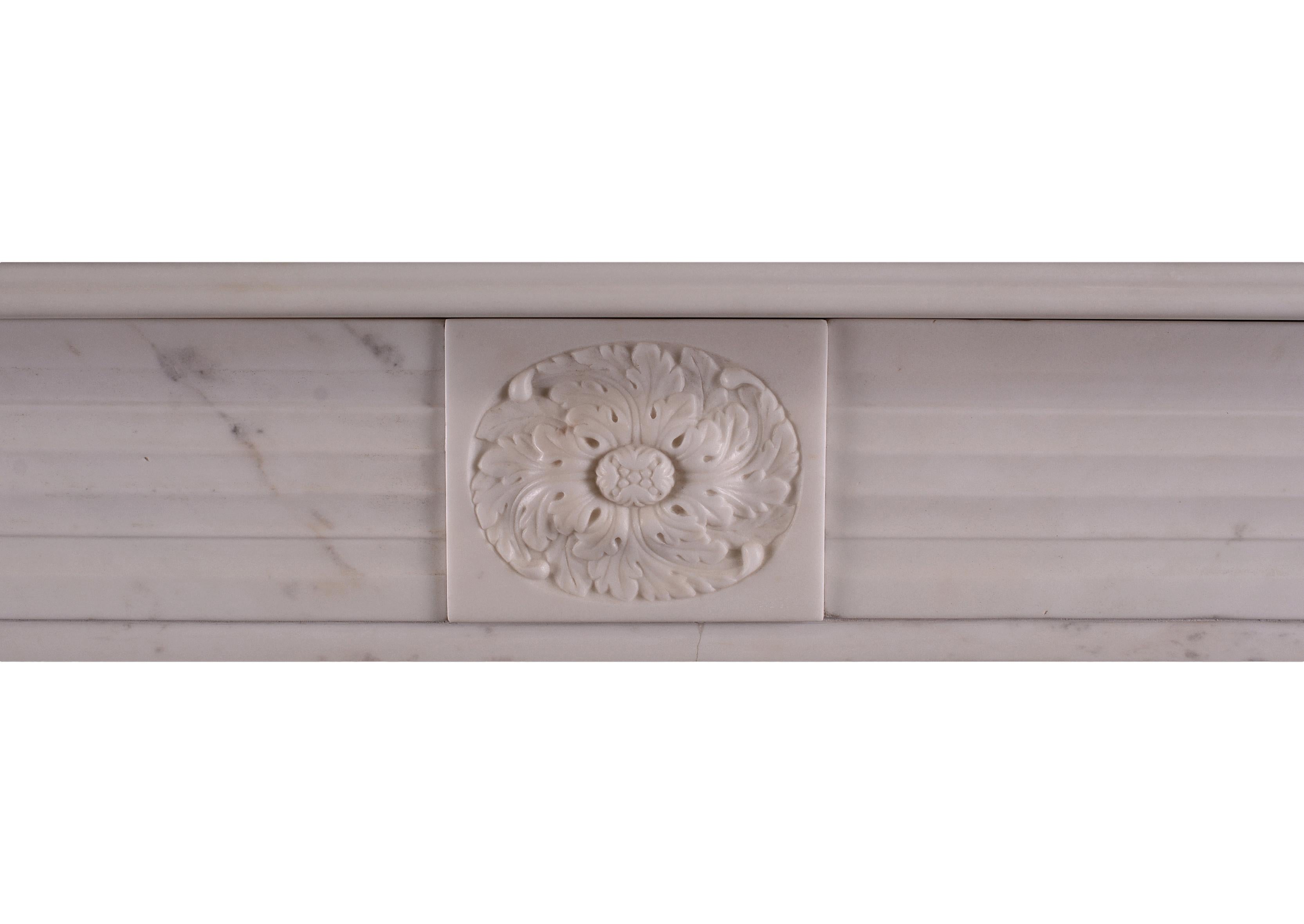 A period English Regency fireplace in statuary marble. The jambs with half rounded reeds surmounted by roundel end blockings. Carved central paterae to frieze, English, circa 1820. One of a very near pair with stock no 3961.

Measurements:
Shelf