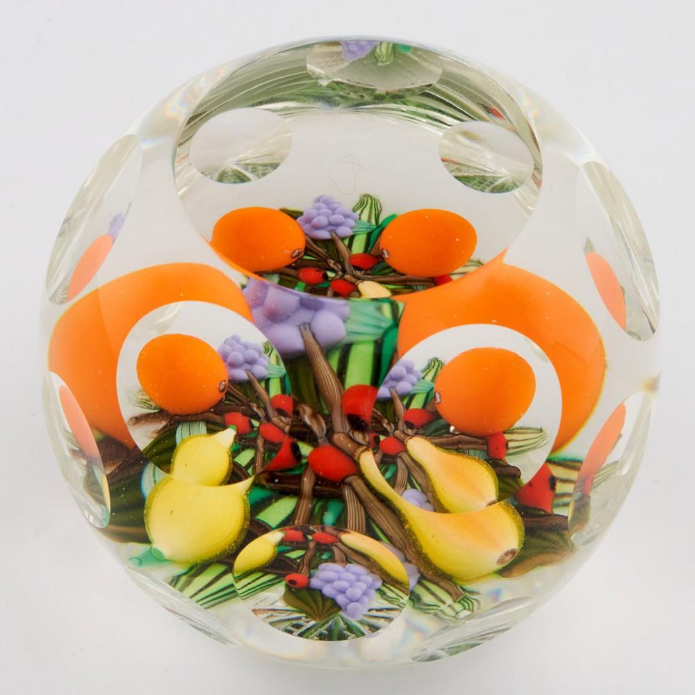 A Perthshire Lampwork Fruit Paperweight, 1994

Additional information:
Date : 1994
Origin : Scotland
Features : Two oranges, two bunches of grapes, a pear, a lemon and several cherries on a bed of leaves on a clear ground. One top facet, eighteen