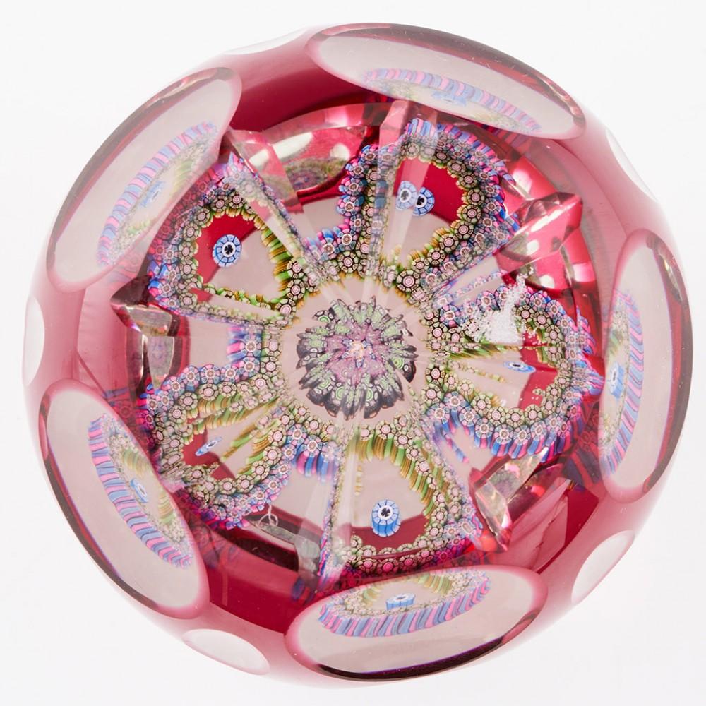 A Perthshire Magnum Overlaid Garland Paperweight, 1992

Additional information:
Date : 1992
Origin : Scotland
Features : A magnum weight with a central cluster cane surrounded by a two colour double garland of five loops on a clear ground with ruby